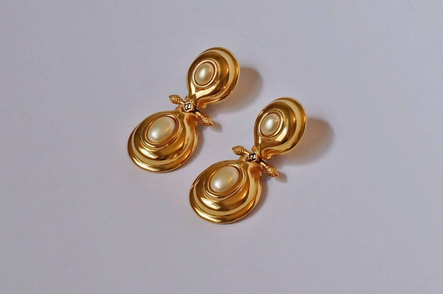 Fendi earrings, faux pearl cabochons set in a gold plated gilt frame, triple signed, Karl Lagerfeld design, circa 1980s, Italian.

These earrings are likely designed by Karl Lagerfeld as they are from the period when he was involved in the Fendi