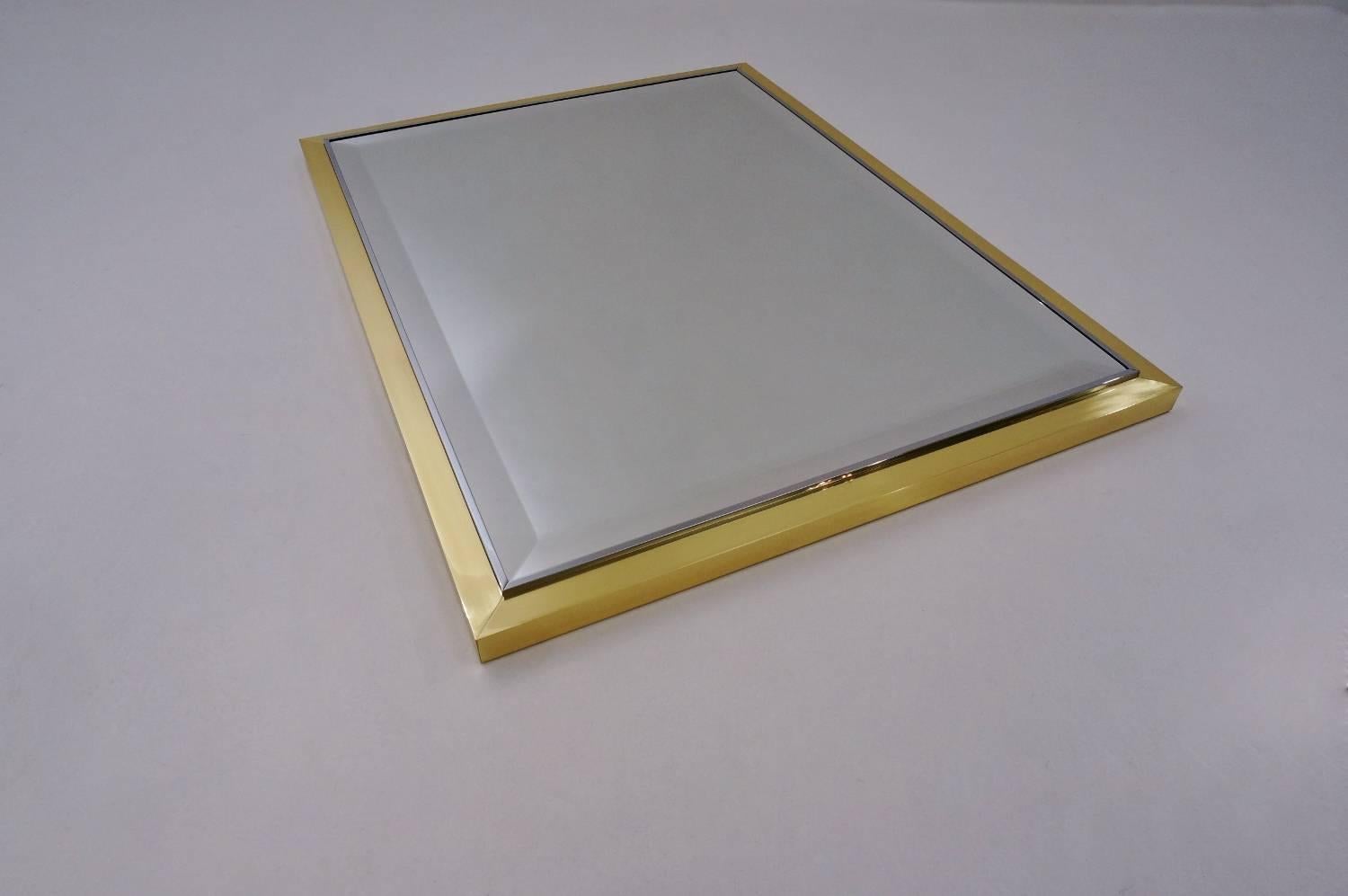 Willy Rizzo wall mirror with a brass and chrome frame, circa 1970s, Italian.

This vintage mirror has been thoroughly cleaned respecting the original lacquer and antique patina. It is ready to hang.
This Modernist mirror is attributed to Italian