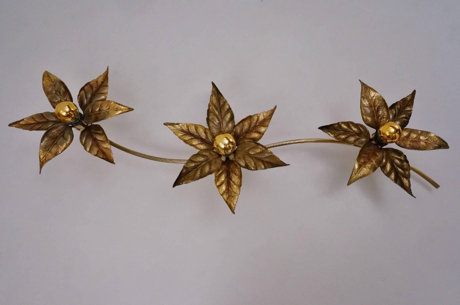 Brass flowers ceiling or wall light in the style of designer Willy Daro manufactured by 'Massive Lighting', circa 1970s, Belgian.

Thoroughly cleaned respecting the vintage patina, newly rewired and earthed. It is in full working order and ready