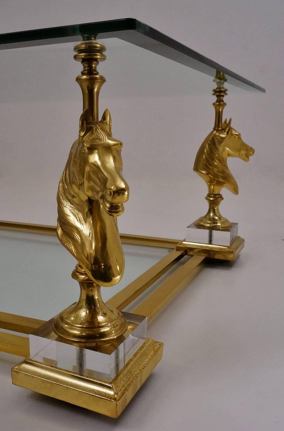 Maison Charles cheval coffee table, brass and Lucite, circa 1970s, French.

This coffee table has been gently cleaned respecting the vintage patina, it is ready to use.

This vintage coffee table with solid brass horse head columns and