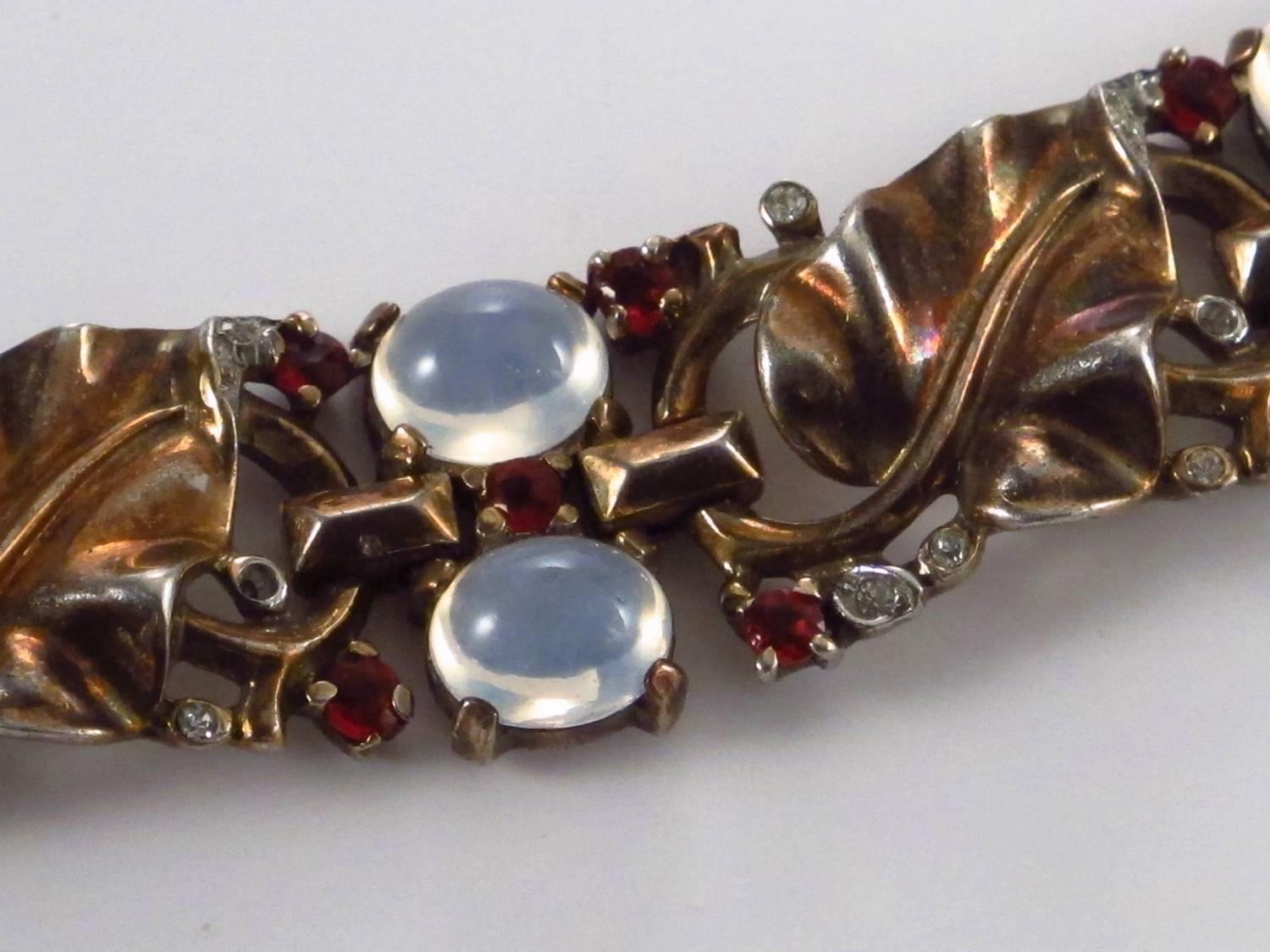 Trifari vintage bracelet moonstones on vermeil gold gilt sterling silver, Alfred Philippe, circa 1940s, USA. The pattern two moonstones cabochons surrounded by smaller red and clear rhinestones on a grapevine motif bracelet. Incorporates ten large,
