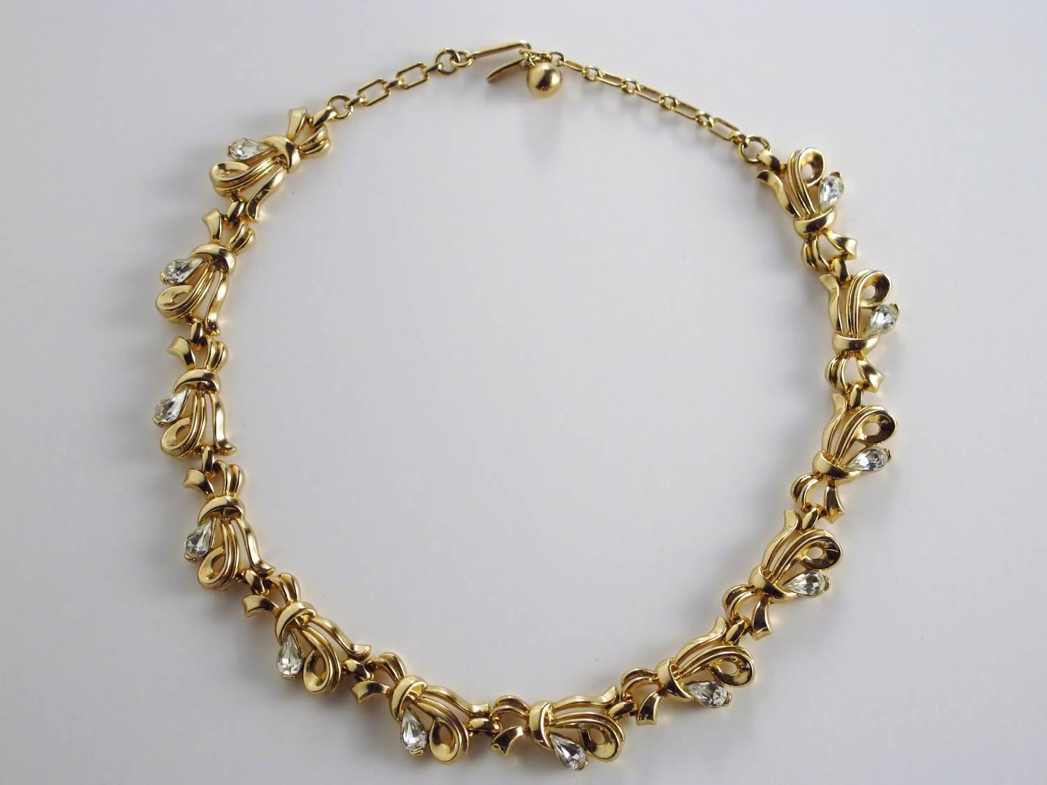 Trifari vintage bow with rhinestones gold tone necklace circa 1950s, USA. Set in gold tone, it features marquis-shape, clear white rhinestones in a bow-style setting. Measure: 15