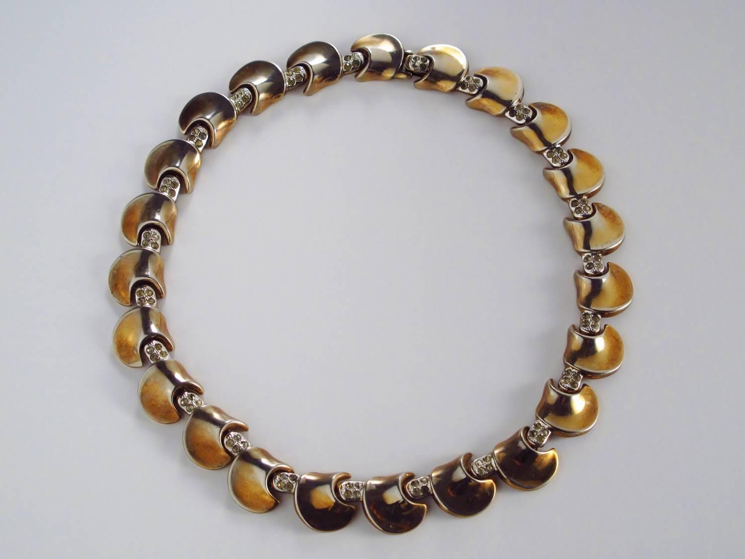 Trifari modernist necklace by Alfred Philippe, circa 1940s, USA. Gold toned choker/collar. Gold-plated pods separated by a group of four rhinestones. Stamped Trifari Des Pat Pend Corp which is a mark from the 1940s. This necklace appeared in this