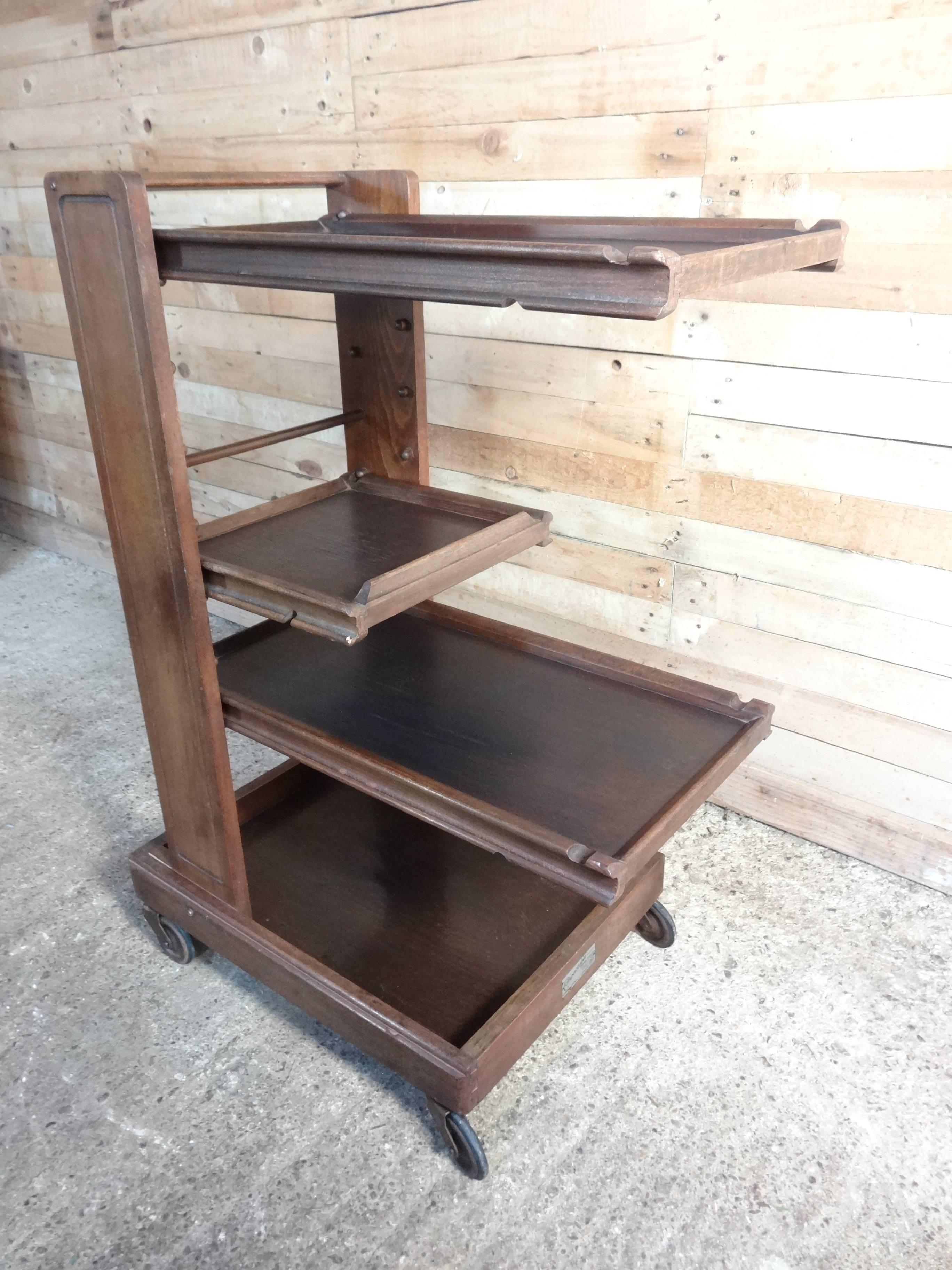 Rare Arts & Craft compactable serving trolley with removable trays, can be positioned at any height, it stands on metal wheels.

Made by Compactom ltd London.