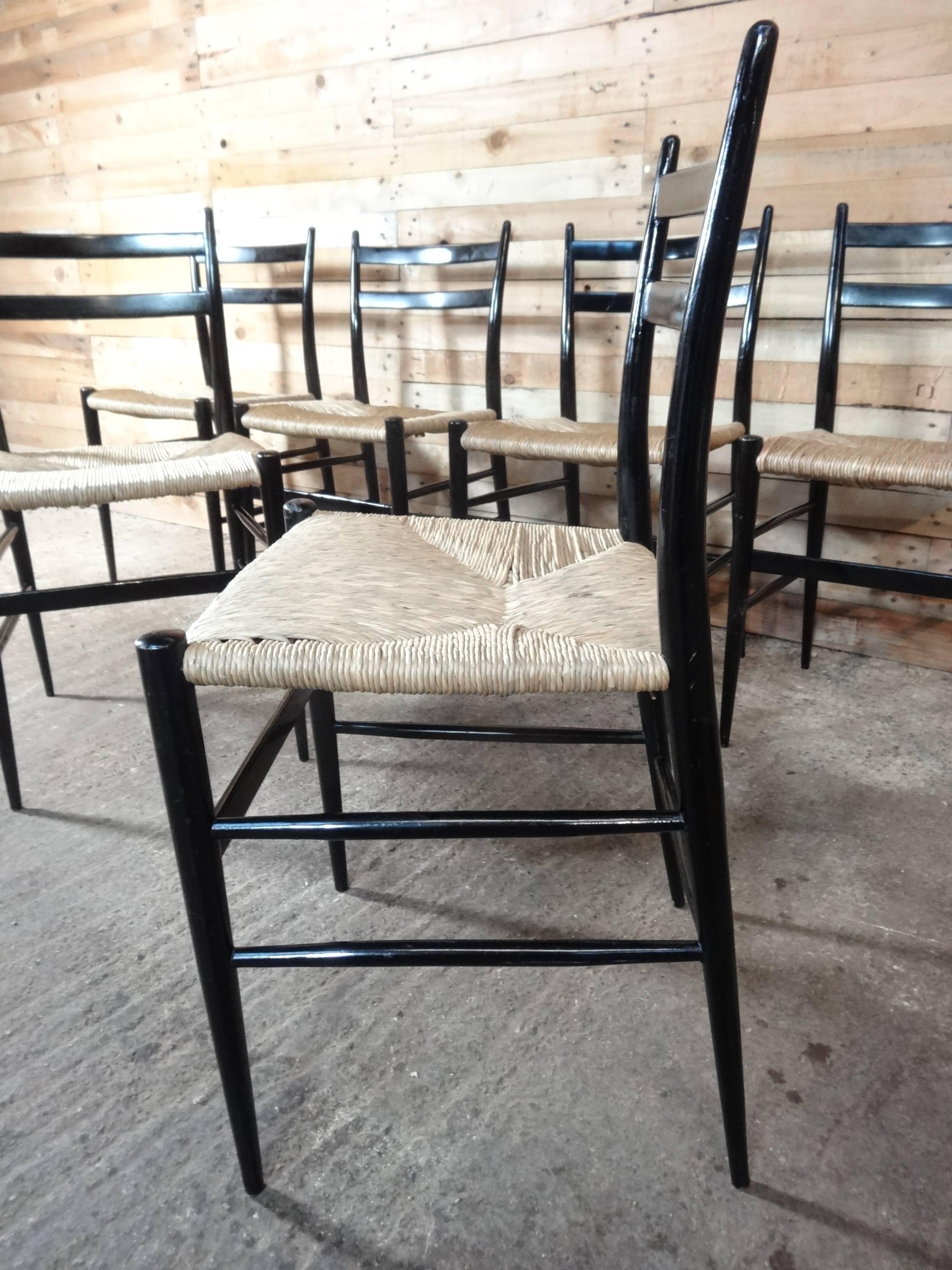 Attributed to Gio Ponti, Italy, circa 1950s chairs.

Super elegant lightweight chairs in great vintage condition 

A set of six ebonized and rush seated dining chairs, twin curved bar back, tapered and rounded frame.

Measures: Seat H 46cm,