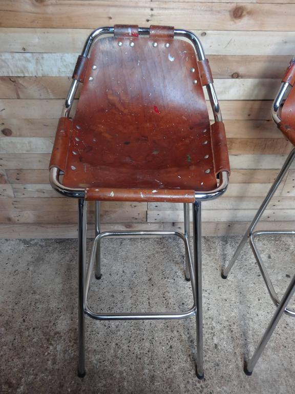 Stunning set of two stools, bought from a dealer in France who bought them from a painter who had them for the last 40 years in his painting studio, which explains the paint on the leather! Designer Charlotte Perriand used these in the Ski Resort