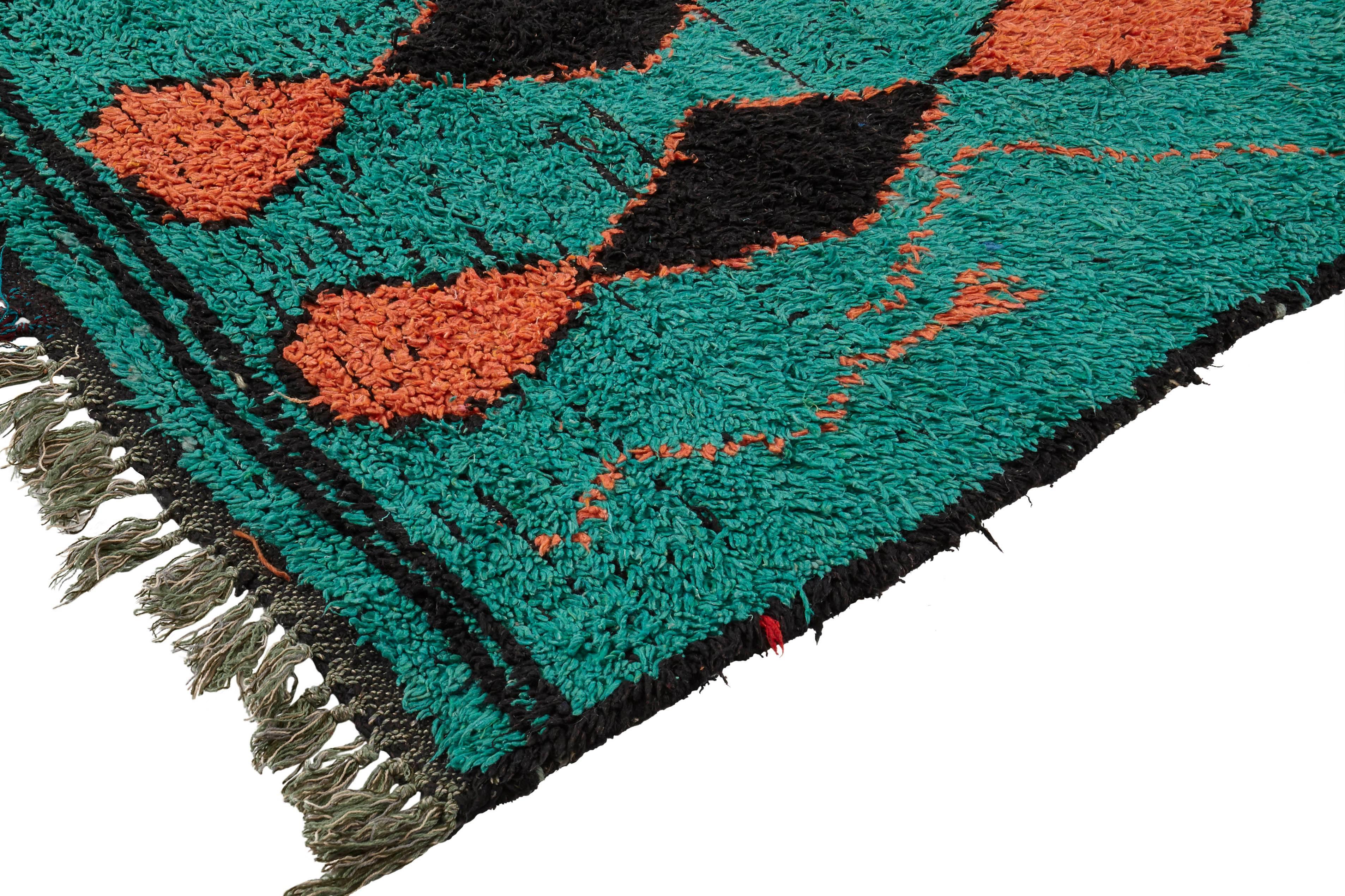 Vintage Moroccan rug

Sourced from Morocco, this vibrant rug has been hand woven with wool. It is soft to touch with a medium-long pile. There is a black underneath, with mainly bright aqua green and a coral, black and ultramarine blue diamond