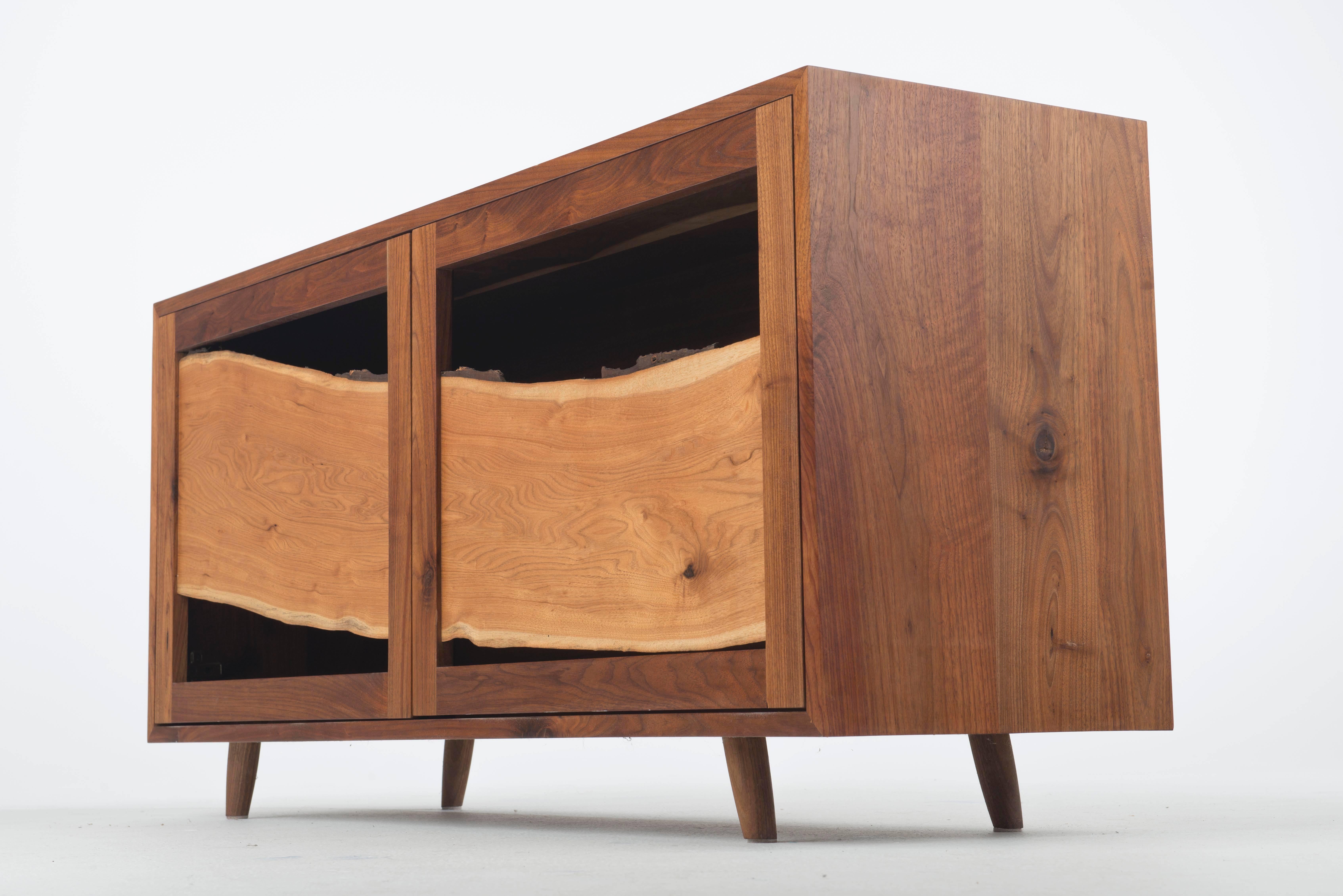 Juxtaposition. Curve with angles. Dark with light. Mass with void. Strength in design lies in the ability to create opposition and tension without becoming incongruous. The central panel in this sustainably made cabinet is a single sweeping board of
