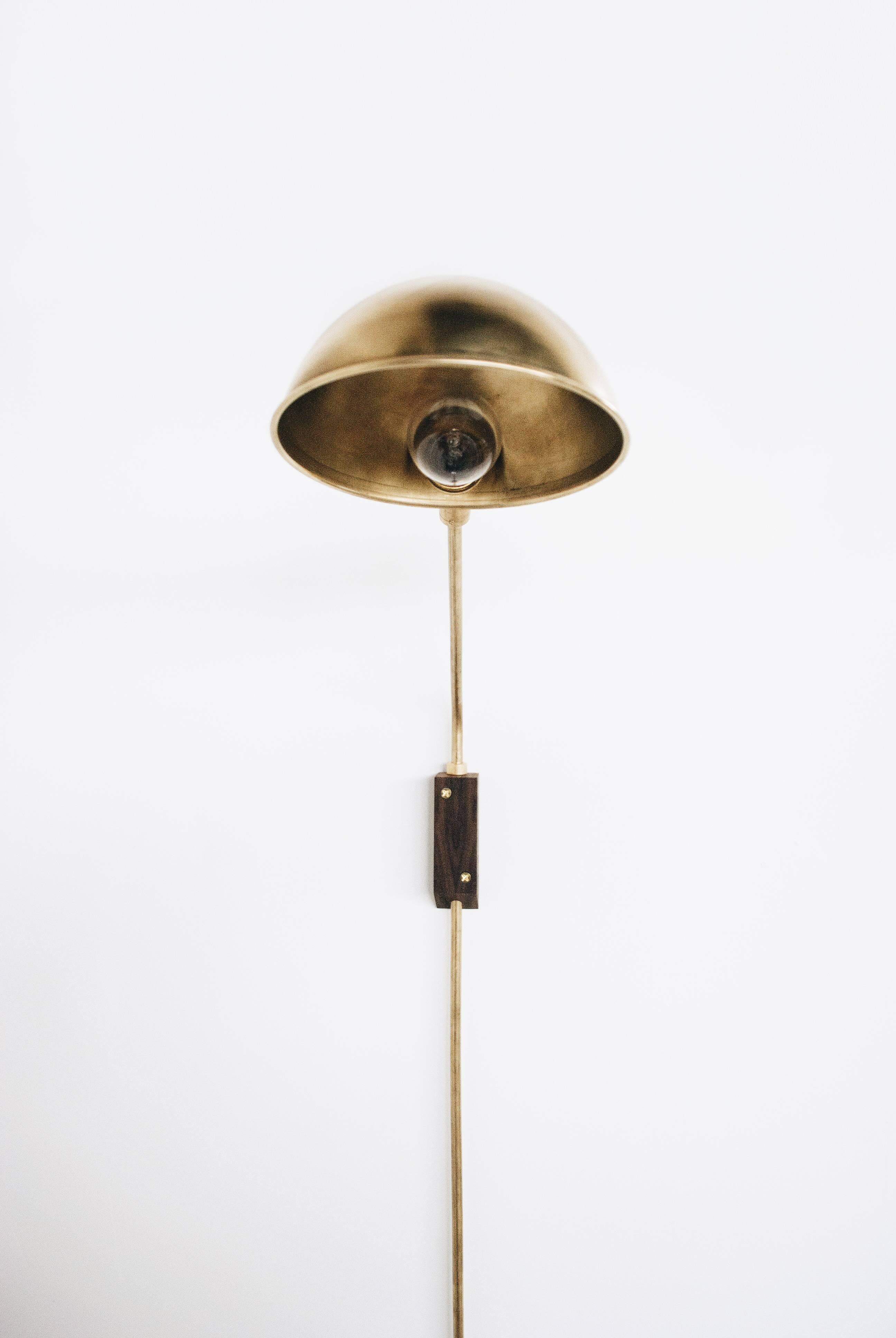 This wall-mounted lamp is comprised of an independently-swiveling arm with a clamp that makes ideal for reading in bed or lighting art. The darkened brass rods can be adjusted in every possible direction making this a very versatile lamp. This lamp