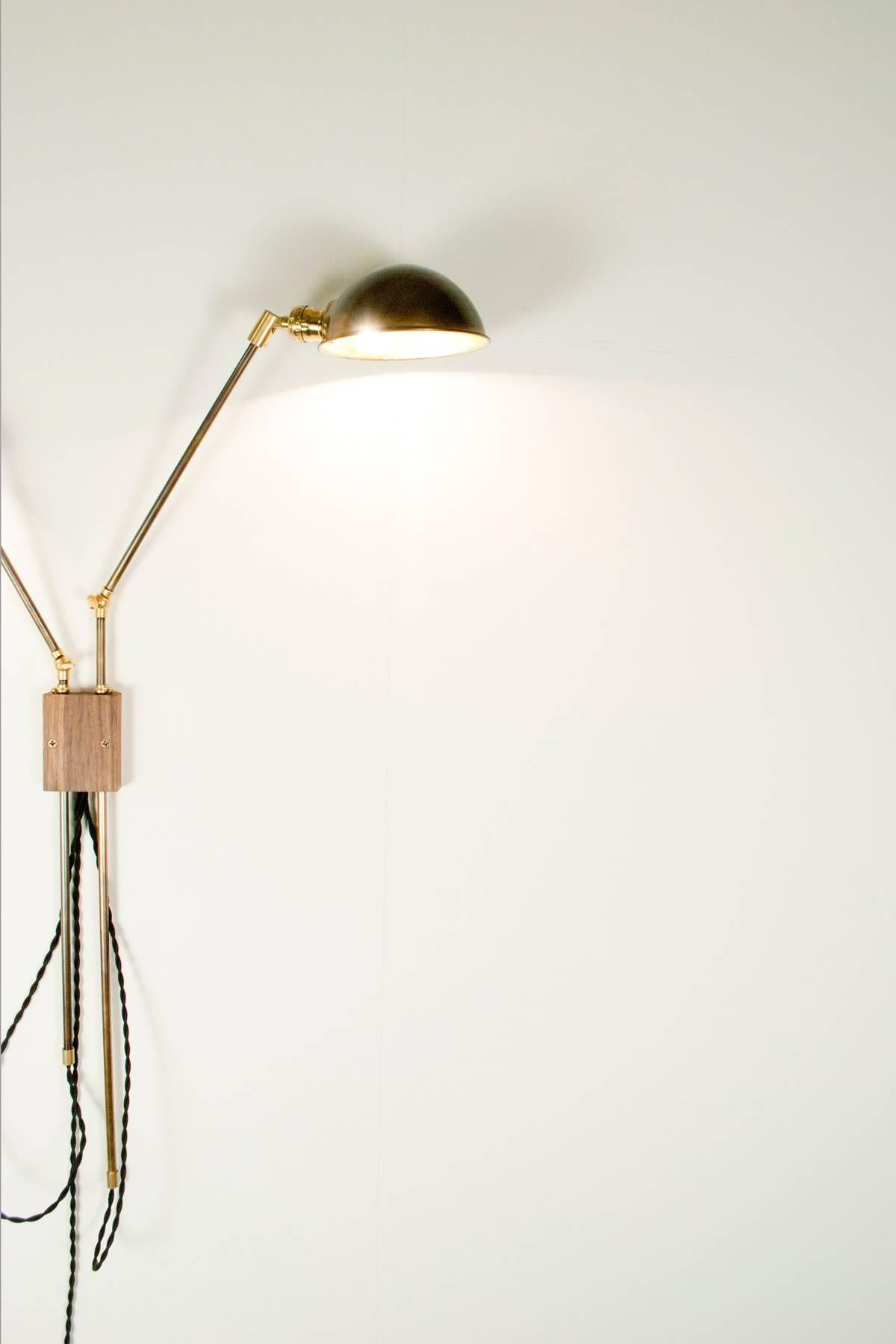 This wall-mounted dual-lamp is comprised of two independently swiveling arms and shades. The darkened brass rods can be adjusted in every possible direction making this a very versatile lamp.

This lamp is extremely customizable in size and