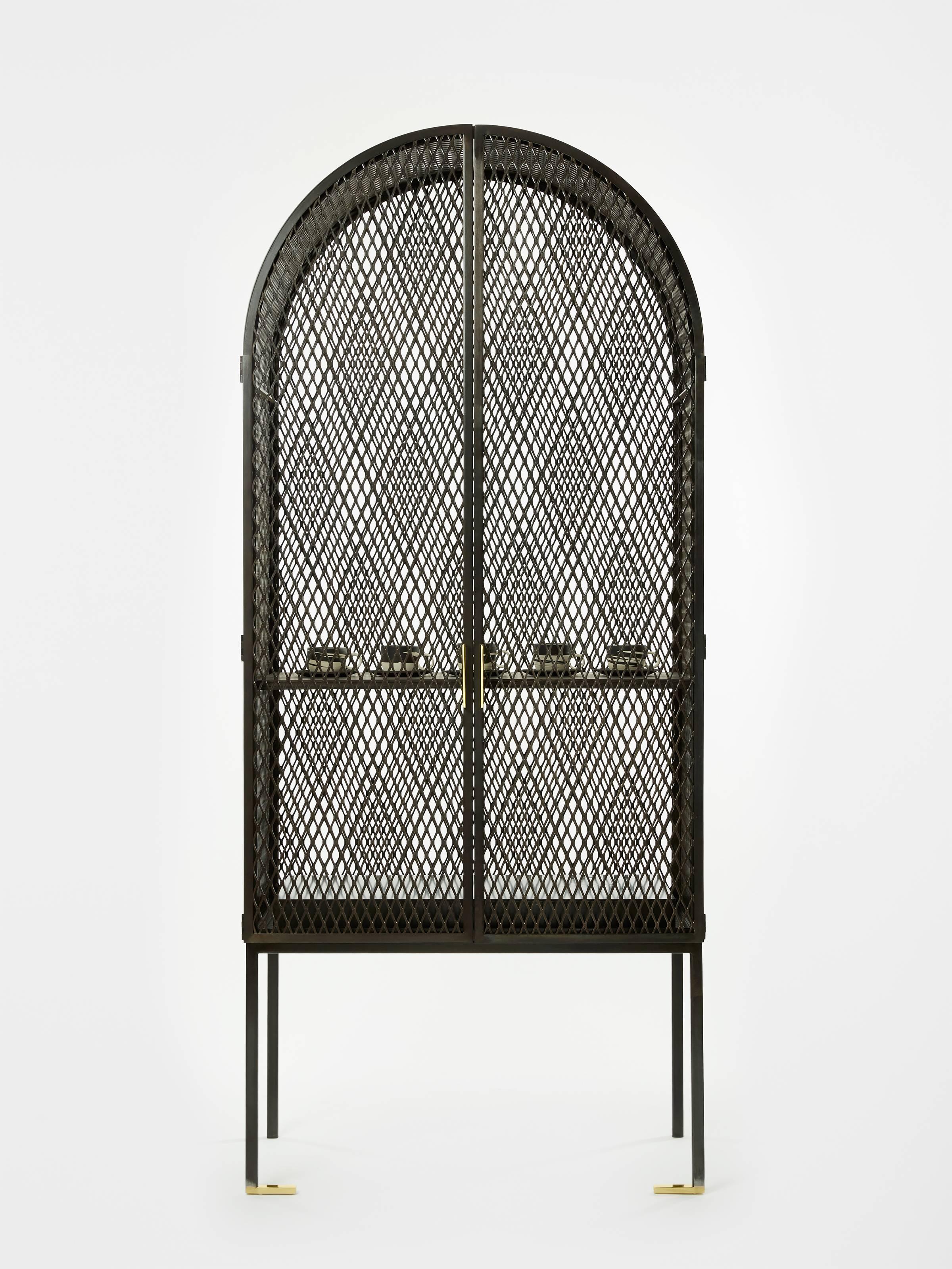 The Louise Cabinet is a study in simultaneity. It combines light with shadow, angles with arches, and blackened metal with glistening brass. 

Inspired by Louise Bourgeois’ ‘Cell’ sculptures, which she describes as dealing “with the pleasure of