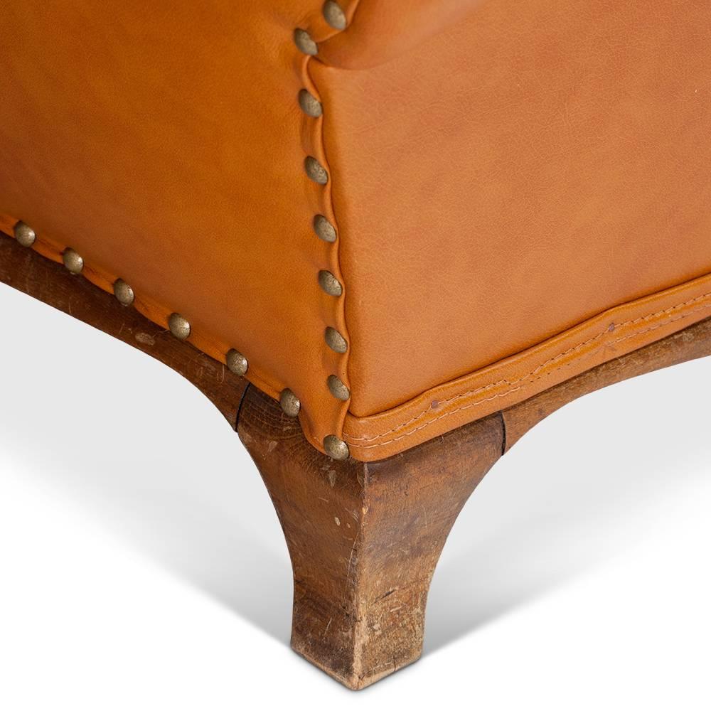 Pair of honey-colored leather mustache club chairs from the 1950s. Sword legs and studded back. Traces of wear, slightly torn armrests.