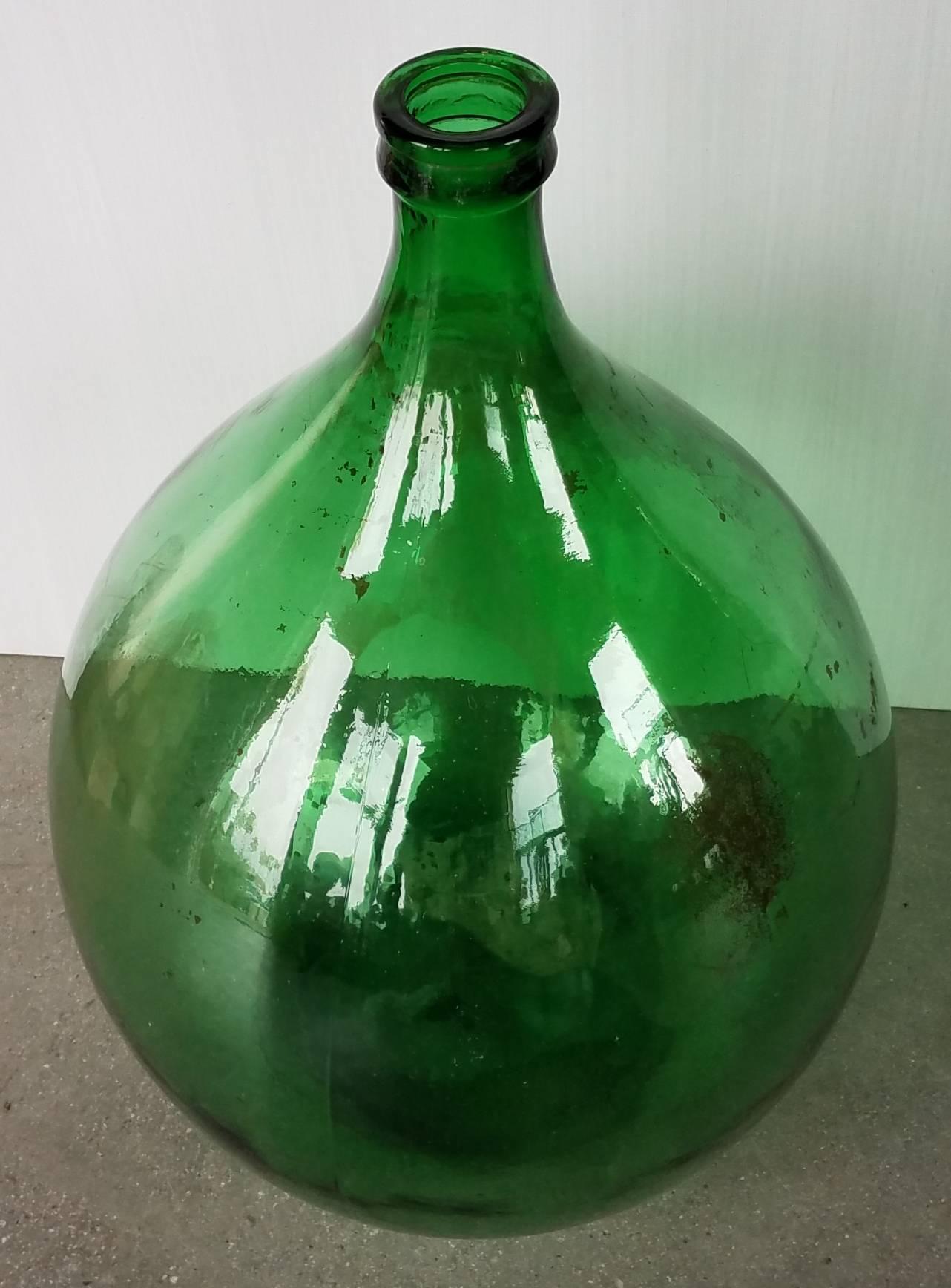 This antique Demijohn has beautiful green tone and has no chips or damage.  It has some residual wine left along the inside but what culd be cleaned easily removed.  A statement addition to a vignette,