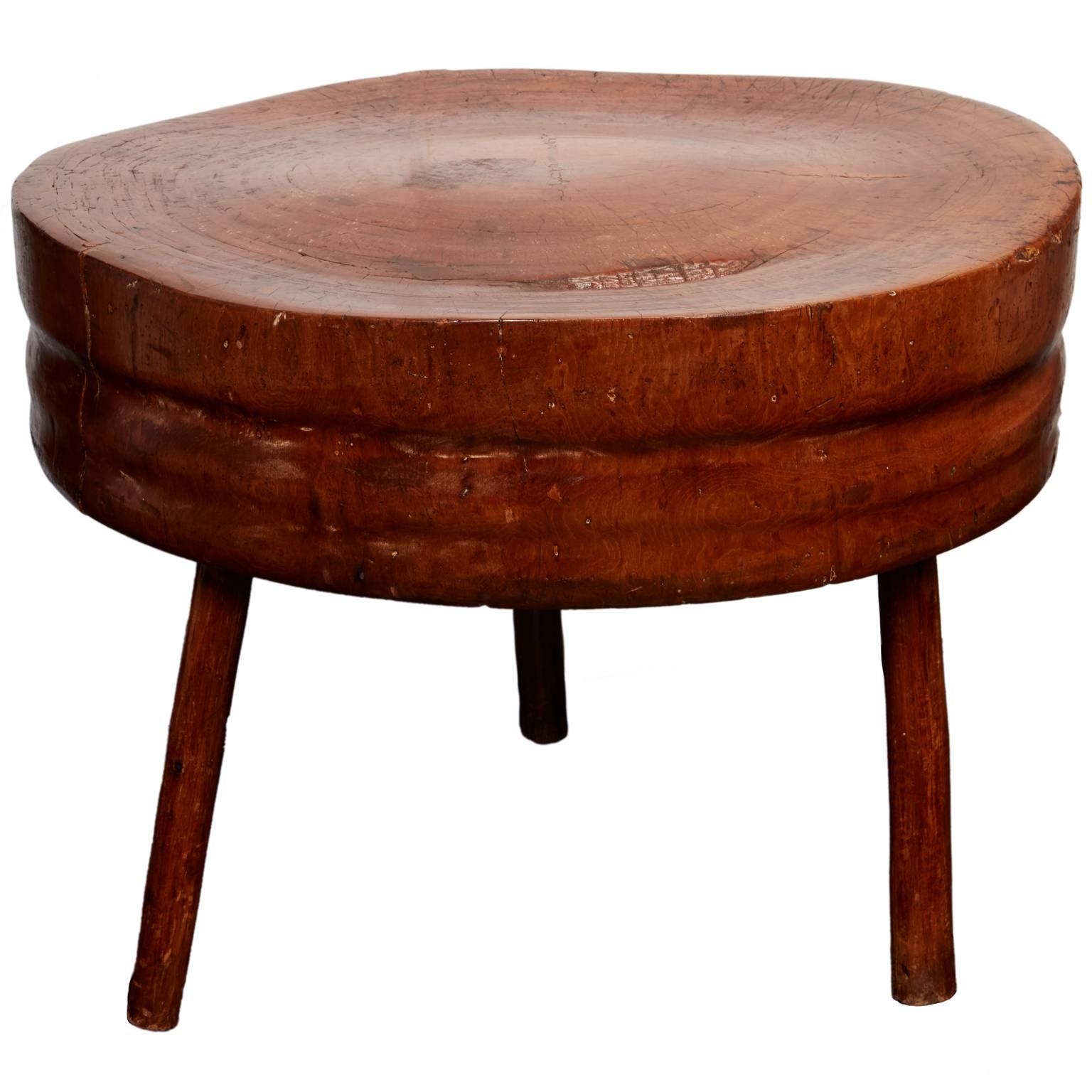 19th and early 20th century blacksmiths and butchers used tree trunk stools for work surfaces, as the weight of the wood easily absorbed the shock of hammers and cleavers. Crafted from a complete tree trunk segment, this pristine three-legged