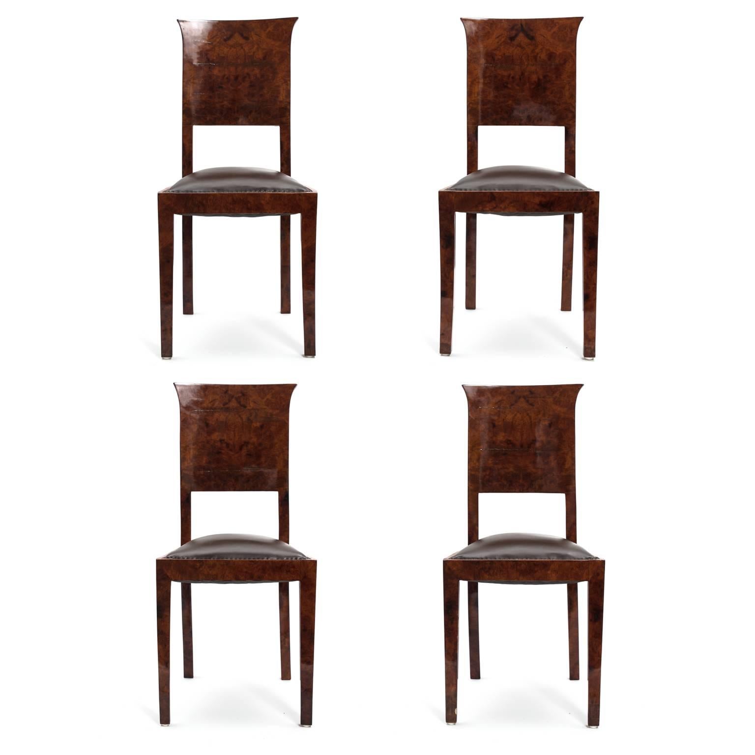 Beautifully grained, polished German burl wood with a rich, red undertone faces every part of these chairs including the legs, seat edges and backrests. The carved seat backs flare out at the top in a slight curve, characteristic of the Art Deco