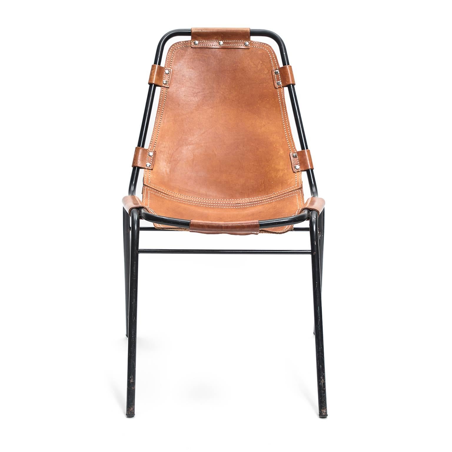 Designed by Charlotte Perriand for the Les Arcs ski resort in Switzerland, this chair features leather sling seats on tubular black metal frames. In her 1929 manifesto, wood or metal, Perriand wrote 