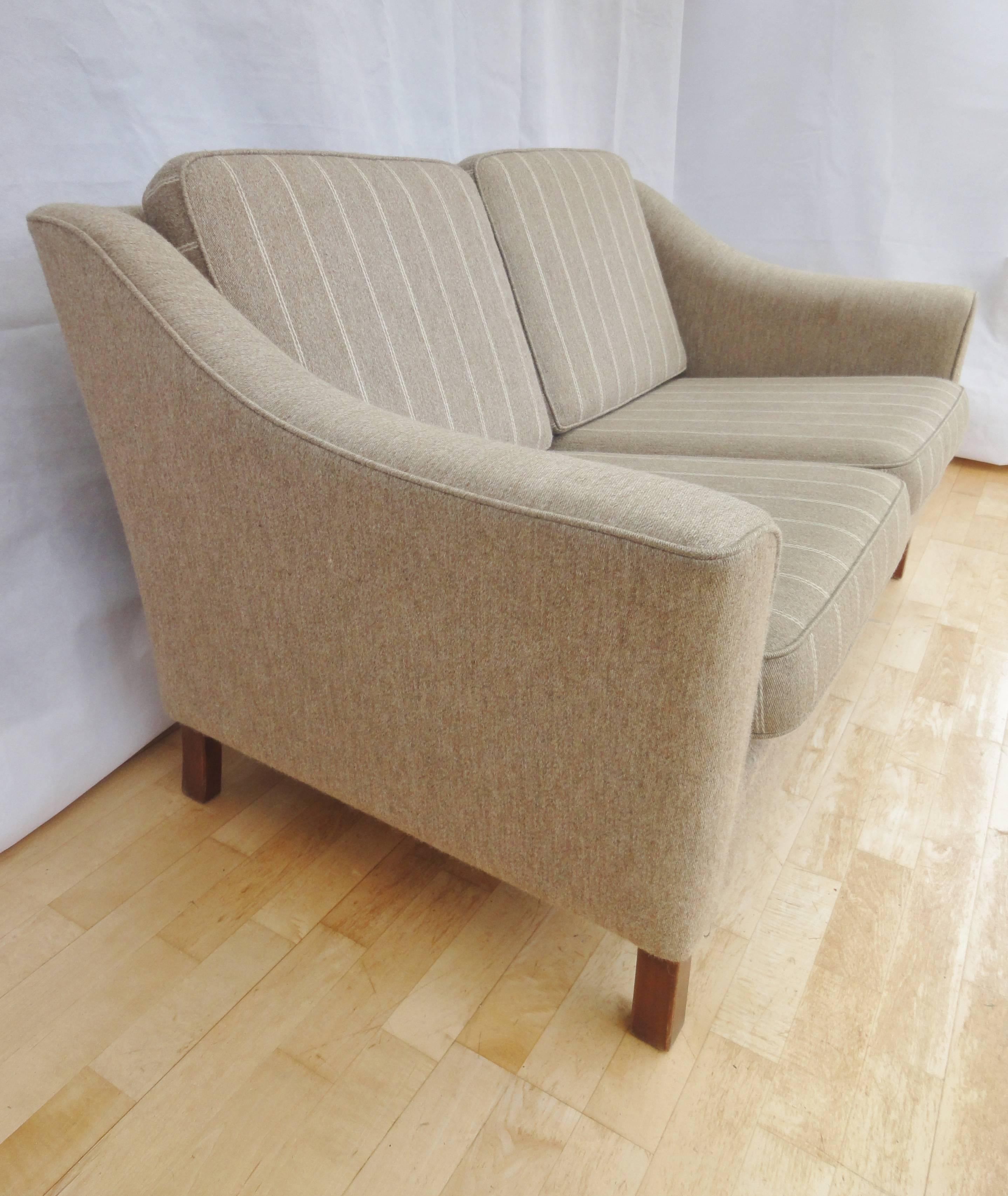 Designer: Danish design.

Manufacturer: Unknown.

Country: Denmark.

Date: 1950s-1960s.

Material: Woollen oatmeal upholstery with lighter pinstripe to the cushions and mahogany legs.

Maximum dimensions: 138cm wide 79cm deep and 78cm