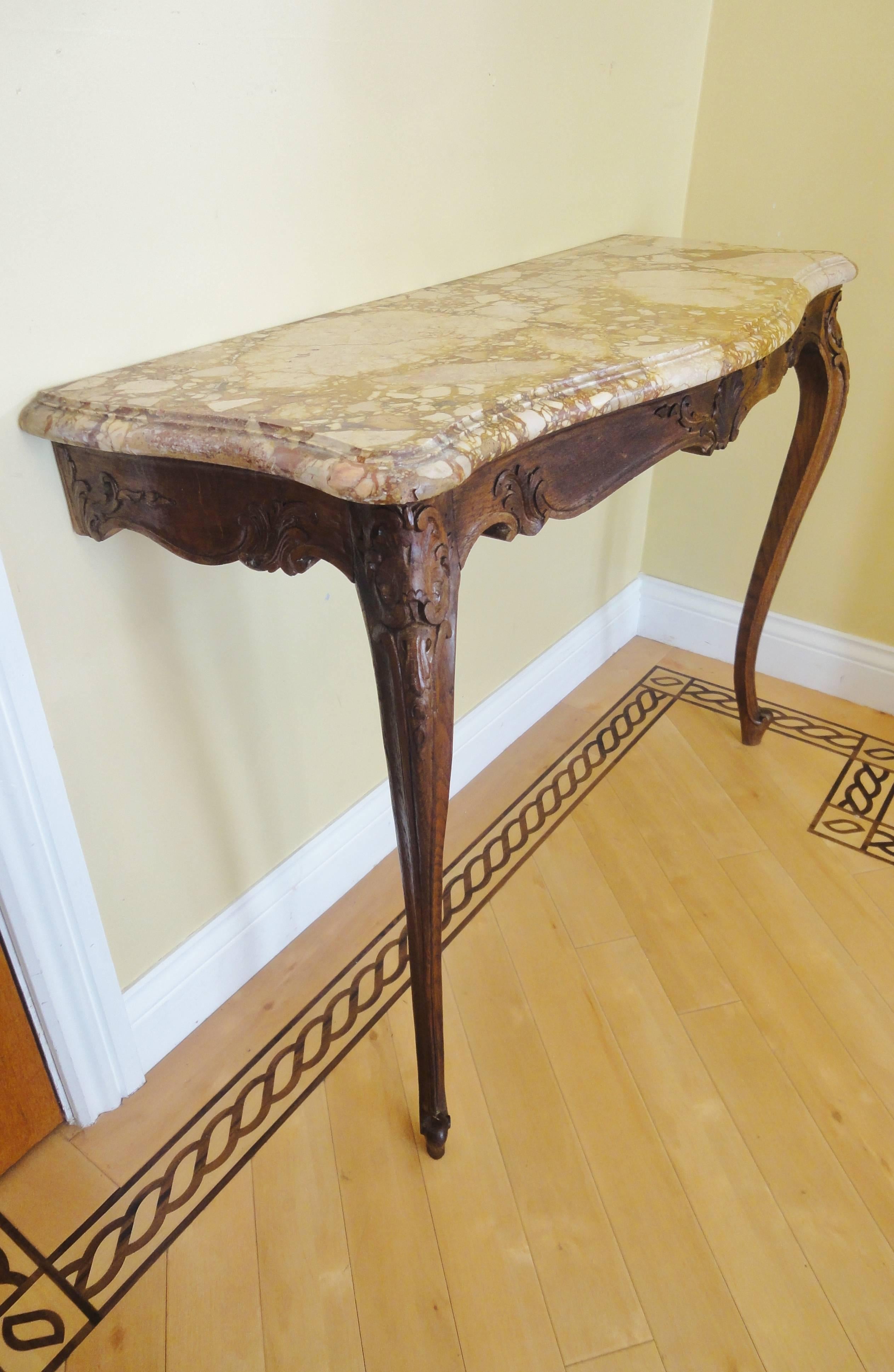 ​Serpentine varigated marble top with deep moulding to front and side.

Over an oak frame deeply carved with foliate detailing.

​Raised upon two elegant cabriole legs terminating in dainty toes.

​There are two fixing brackets to the rear for