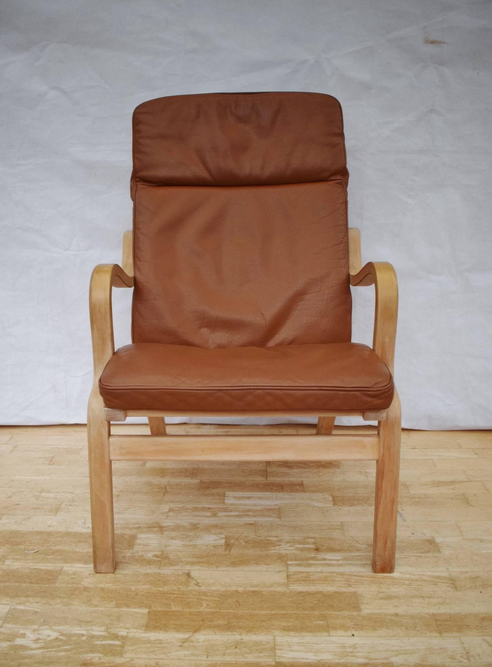 Designer: Danish design.

Manufacturer: Stouby.

Country: Denmark.

Date: 1960s.

Material: Bentwood beech and tan leather.

Maximum dimensions: 63cm wide, 75cm deep, 98cm tall.
Seat height to the front is 43cm.
​Footstool 54cm wide,
