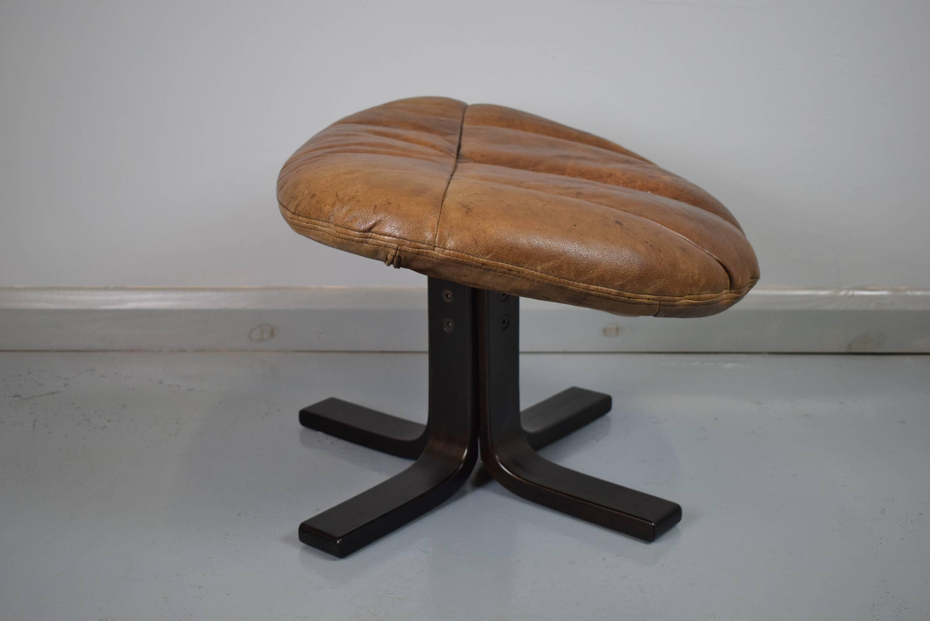 Designer: Danish Design

Manufacturer: Bramin

Country: Denmark

Date: 1970s

Material: Light brown leather and stained beechwood base.

Maximum dimensions: 60 cm wide, 52 cm deep, height to front 39 cm, to the back 30 cm.

Condition: