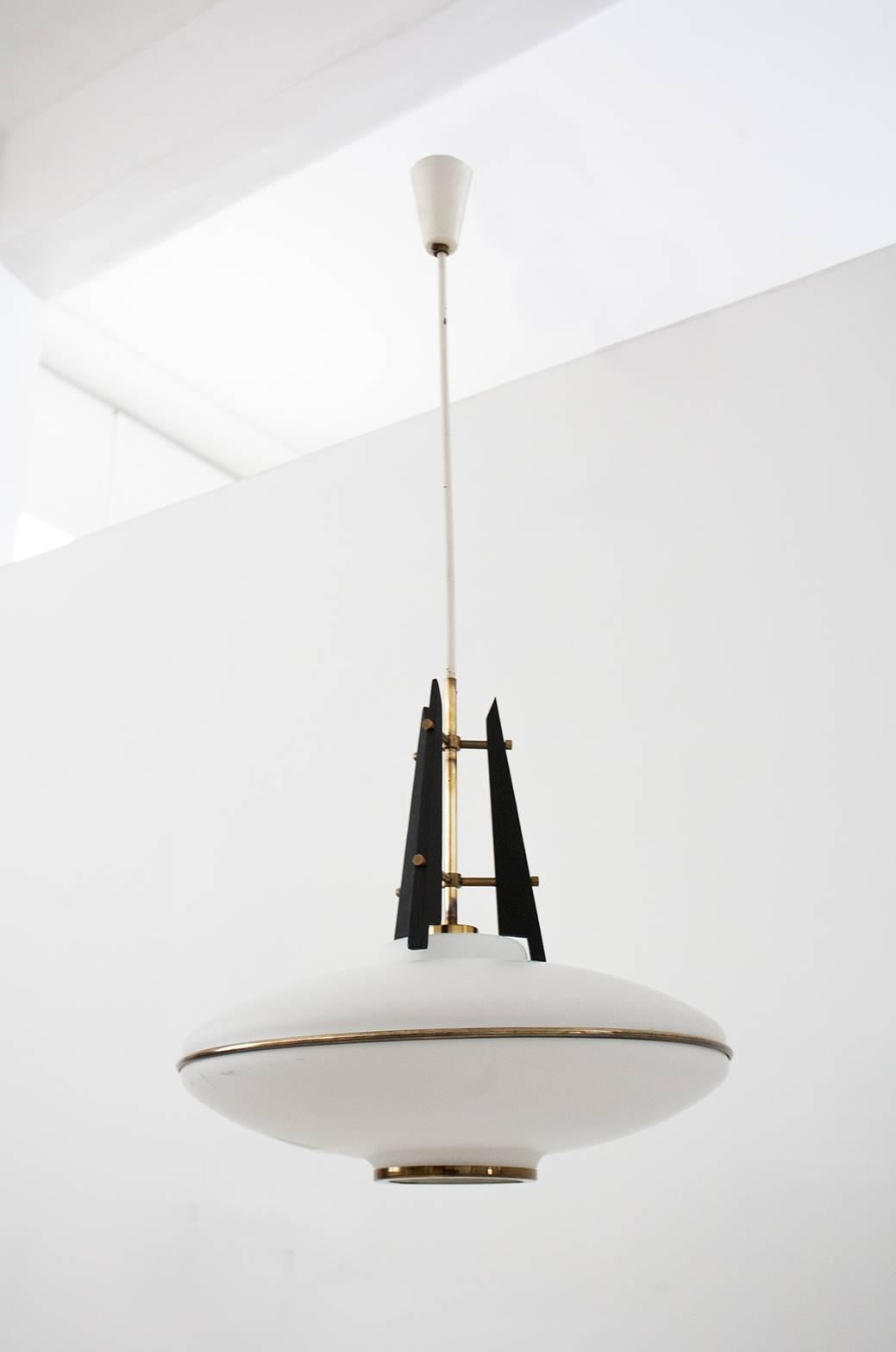 This Mid-Century pendant lamp was made in the 1950s in Italy. It is made from brass, opaline glass and wood. The design is attributed to Stilnovo.