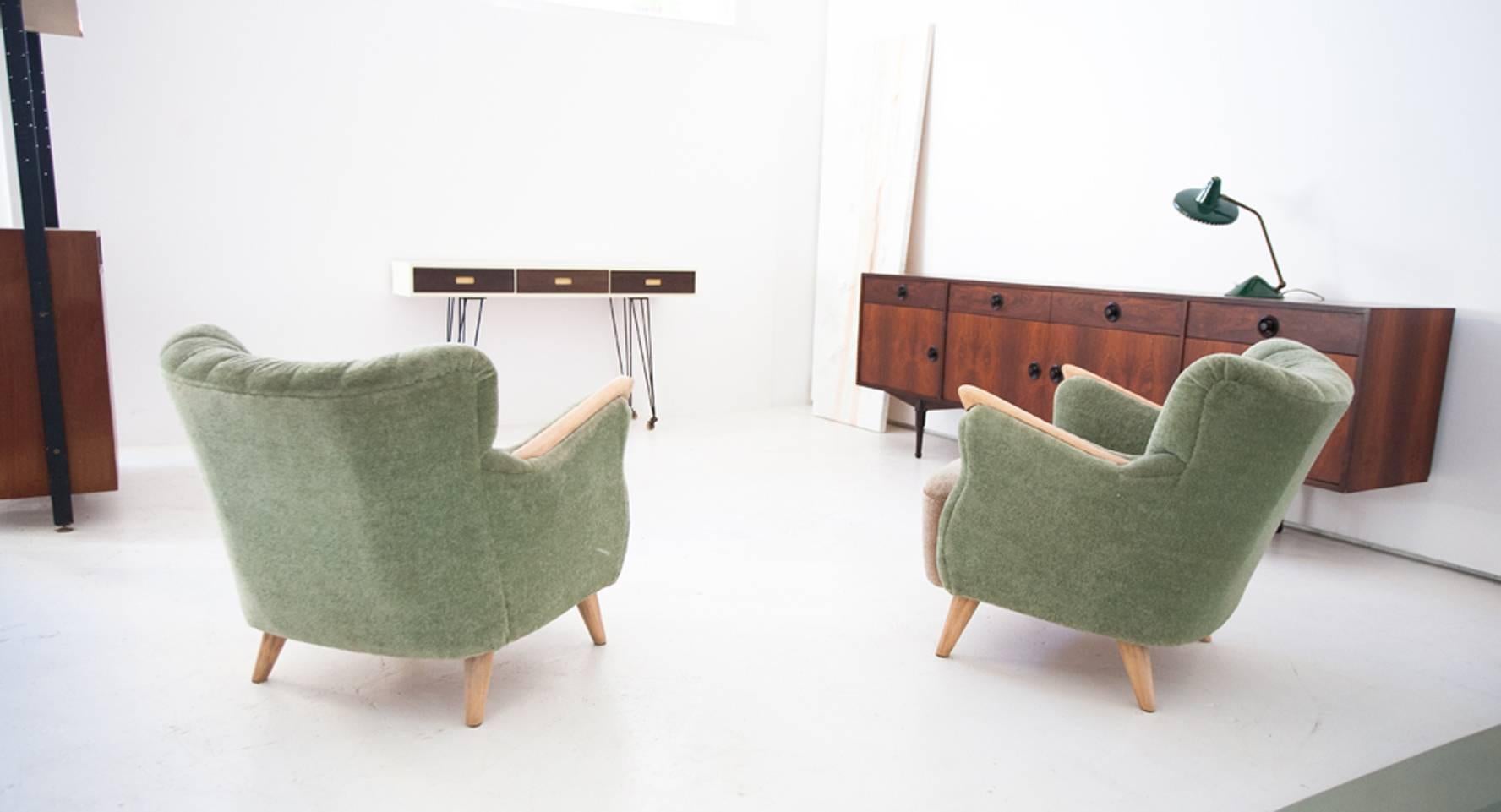 This set of two chairs originates from Denmark and were produced in the 1950s. They are upholstered in the original pastel green and beige fabric.