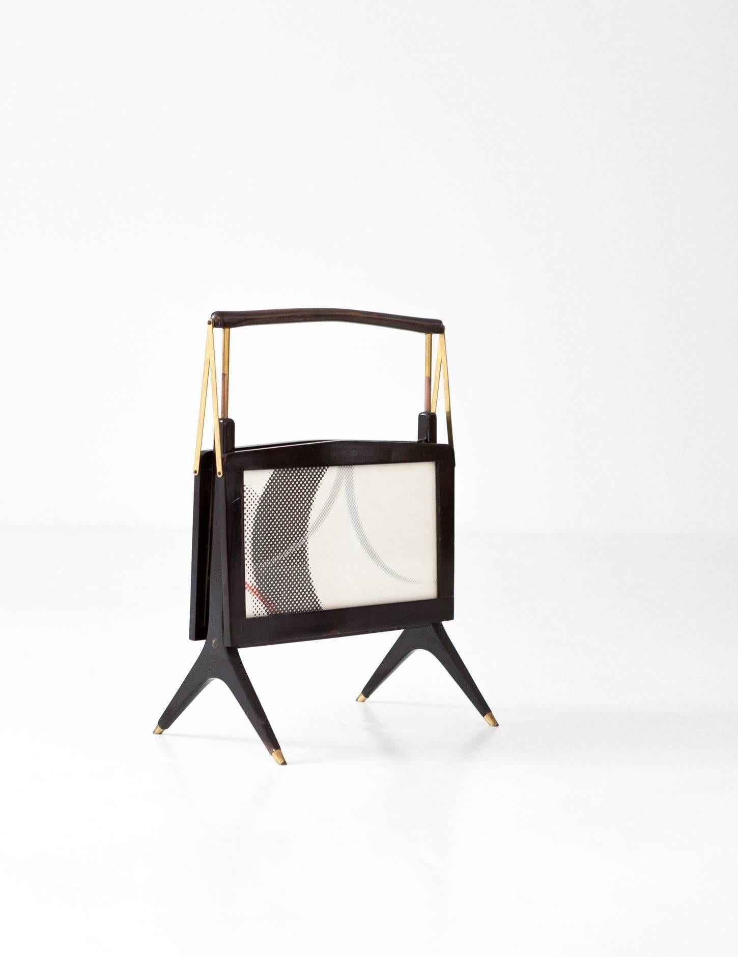 This magazine rack was designed and produced in Italy during the 1950s. The piece is made from wood, glass and brass and is in an excellent vintage condition.