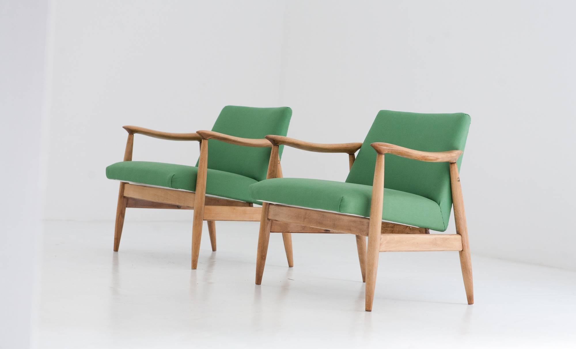 A pair of vintage armchairs designed and produced in Denmark in the 1950s.
New green upholstery. The wood is restored but still lets you see the signs of aging.
 