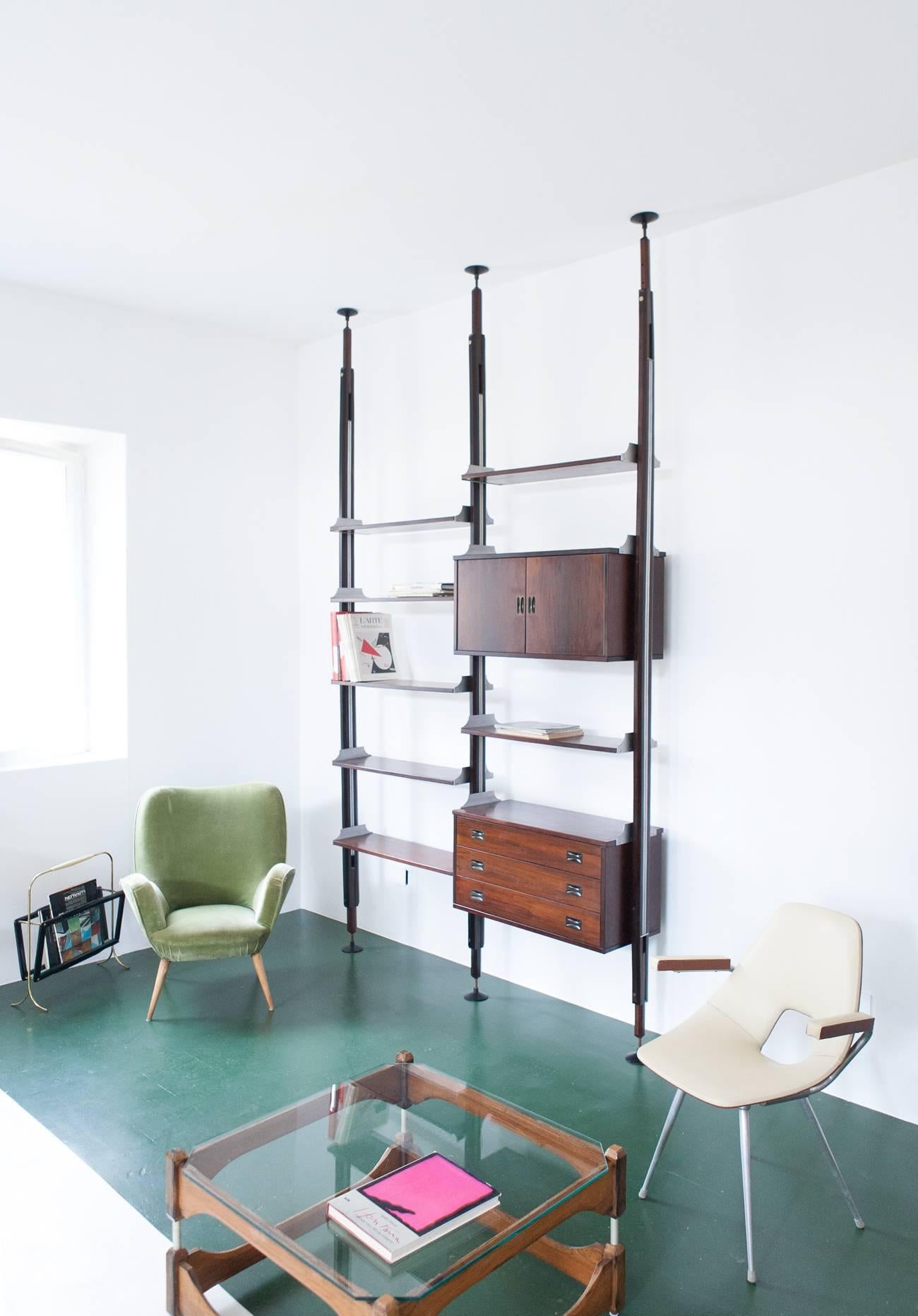A ' floor to ceiling ' modular wall unit produced by Stildomus in Italy in the 1960s.
Made from rosewood and alluminium with solid brass (black lacquered) handles. The piece is restored and in very good conditions. The poles are a little curved and