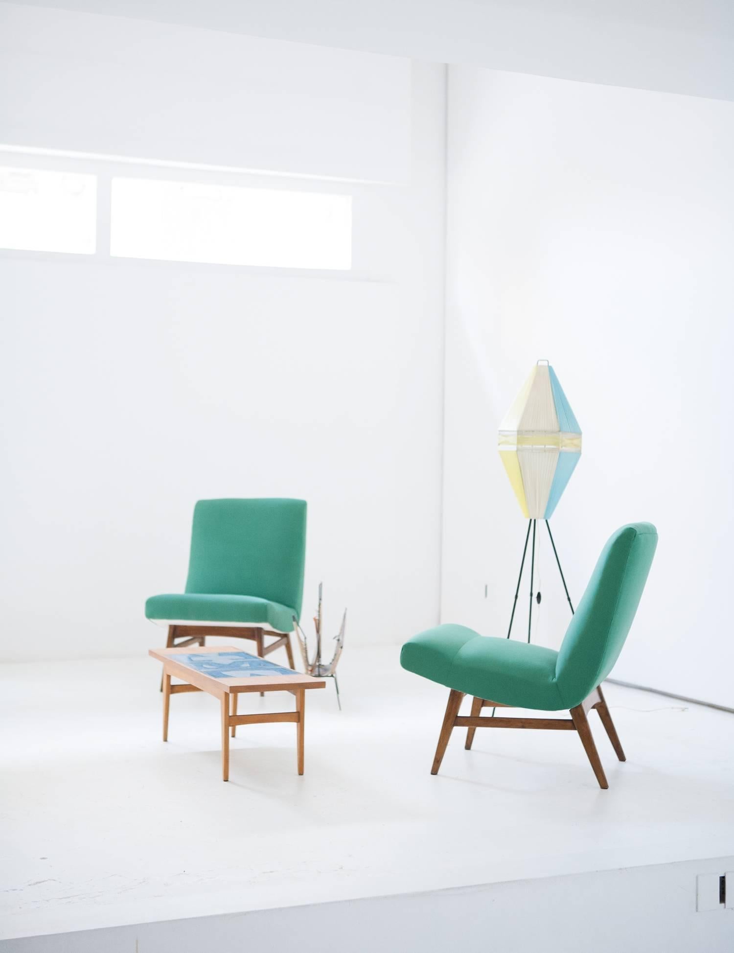 A pair of modern easy chairs, designed and produced in Denmark in the Mid-Century. New gree upholstery.