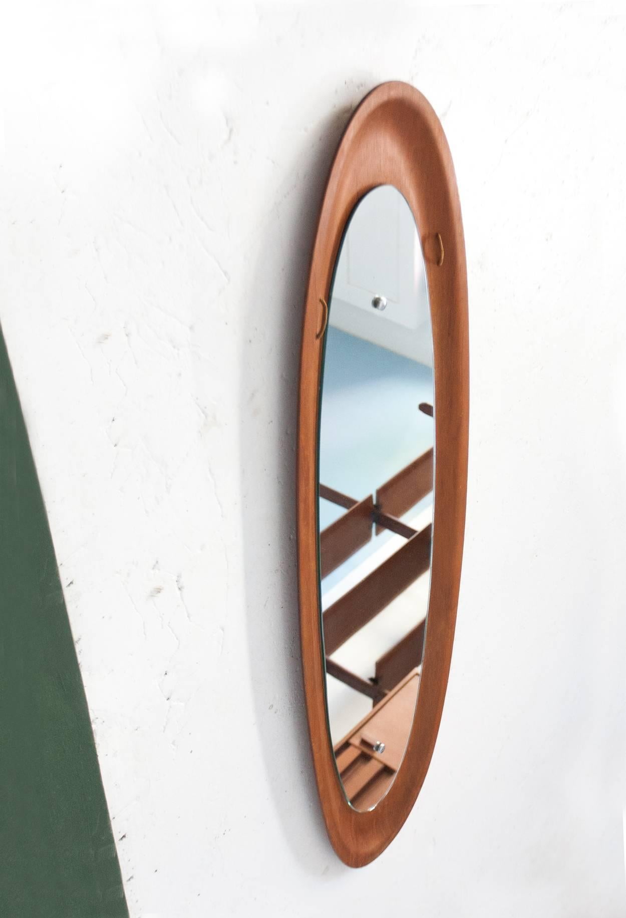 This Mid-Century teak mirror was produced in Italy in the 1950s.