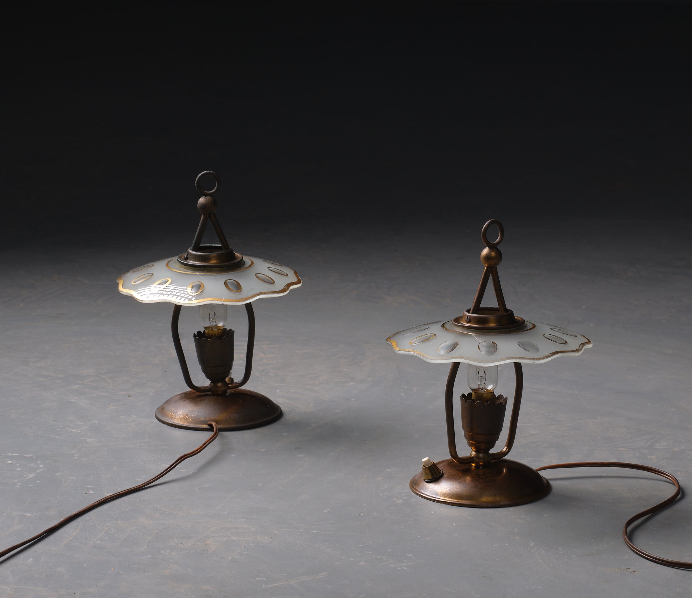 Offered here is a stunning pair of Italian table lamps from the 1950s, each exuding elegance and a rich history. The lamps are crafted from brass, which has developed a gorgeous patina over the decades, adding character and a touch of antiquity to