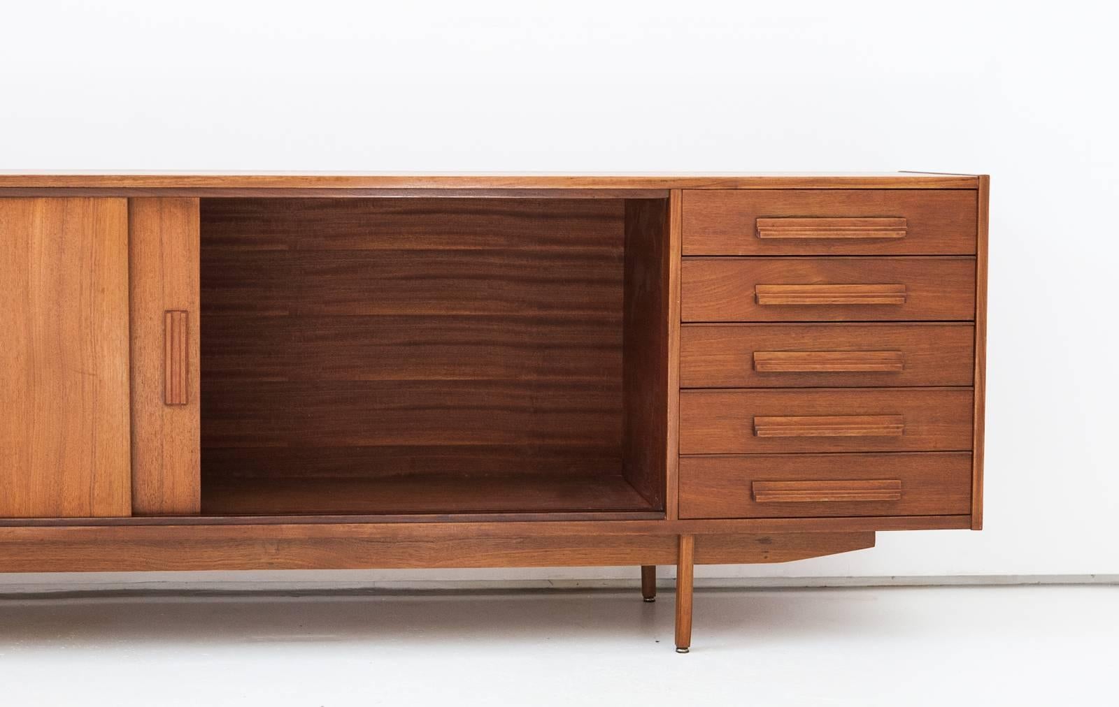 Mid-Century Modern teak sideboard manufactured in the 1950s
Two sliding doors and five drawers
Completely restored