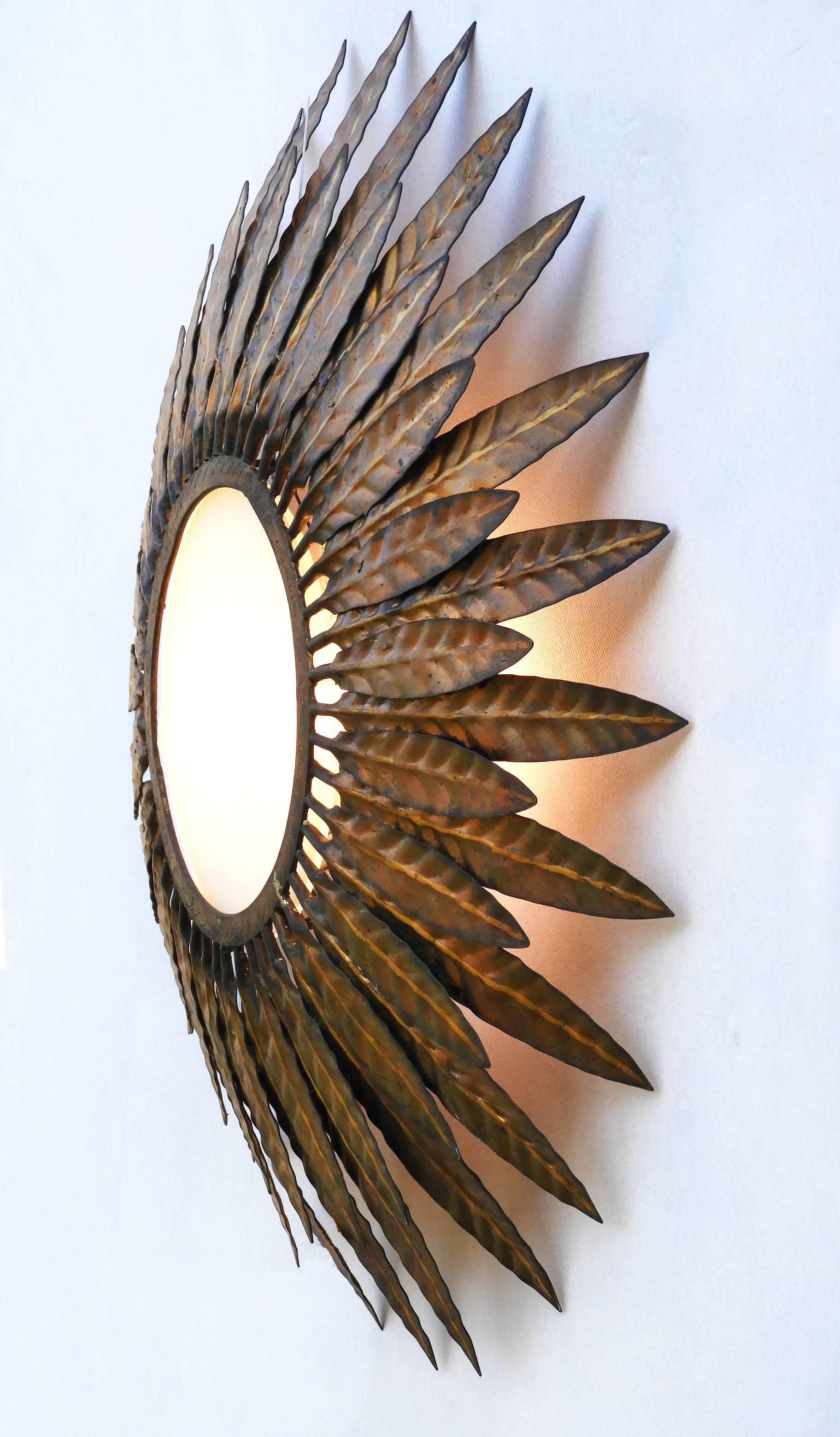 Midcentury wall light sunburst sconce ceiling flush mount Spanish Sunray
Opaque glass centre.
Curved gilt metal tole acanthus leaf frame wonderful patina due to age
This piece can be placed as a wall sconce, flush mount, hanging ceiling lamp or