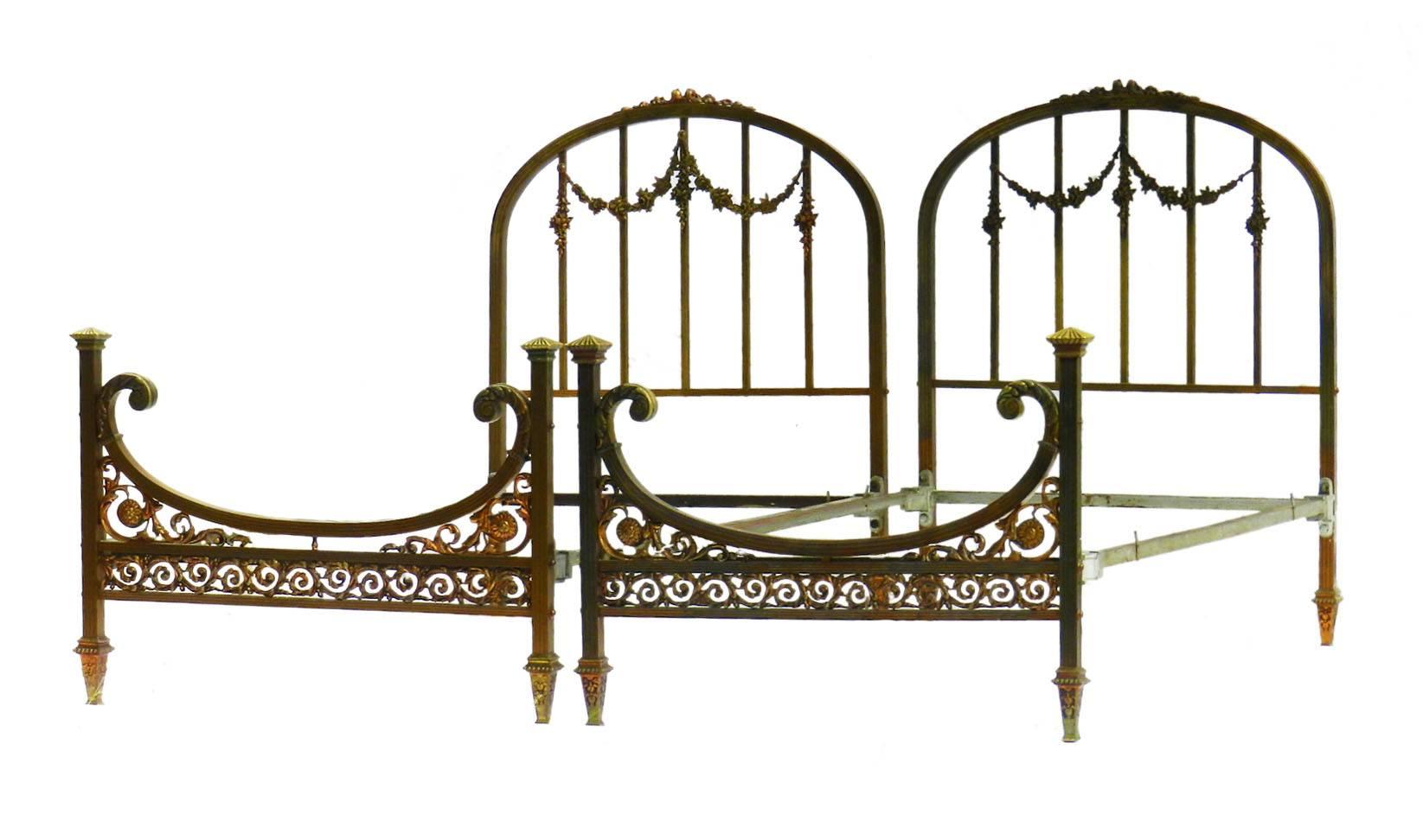 Rare pair of French Twin Beds Belle Époque 
Pair of twin singles
Very unusual bronze, iron and brass
Floral swags
Sound and solid with wonderful patina
These beds will take 3 foot wide mattresses and bases (slats or shallow box spring), we can