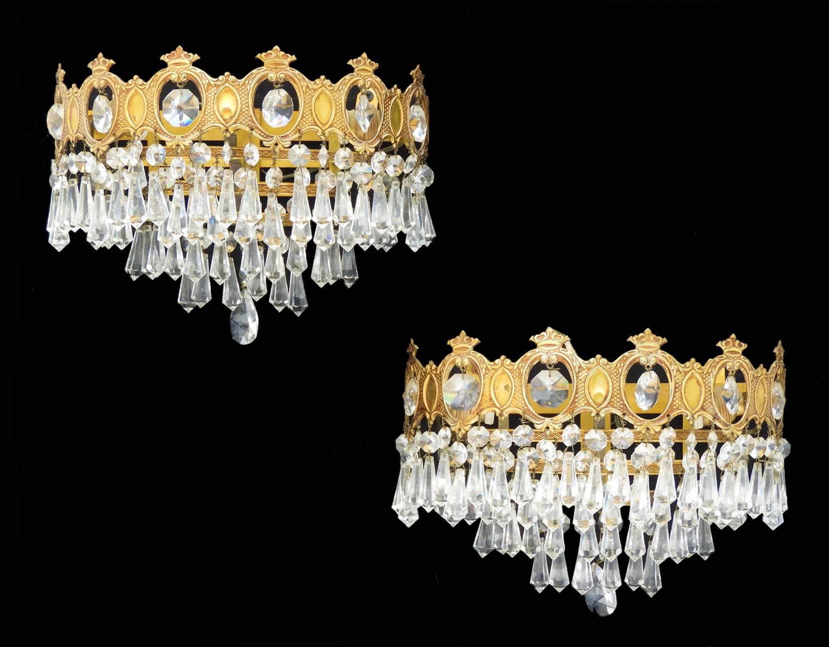 Pair of wall lights faceted cut-glass drops and brass three-tiered half crowns, circa 1920
Three tiers of faceted and prism cut-glass
Crown detailed gilded brass mount in good original condition 
No losses to glass
These will be re-wired and
