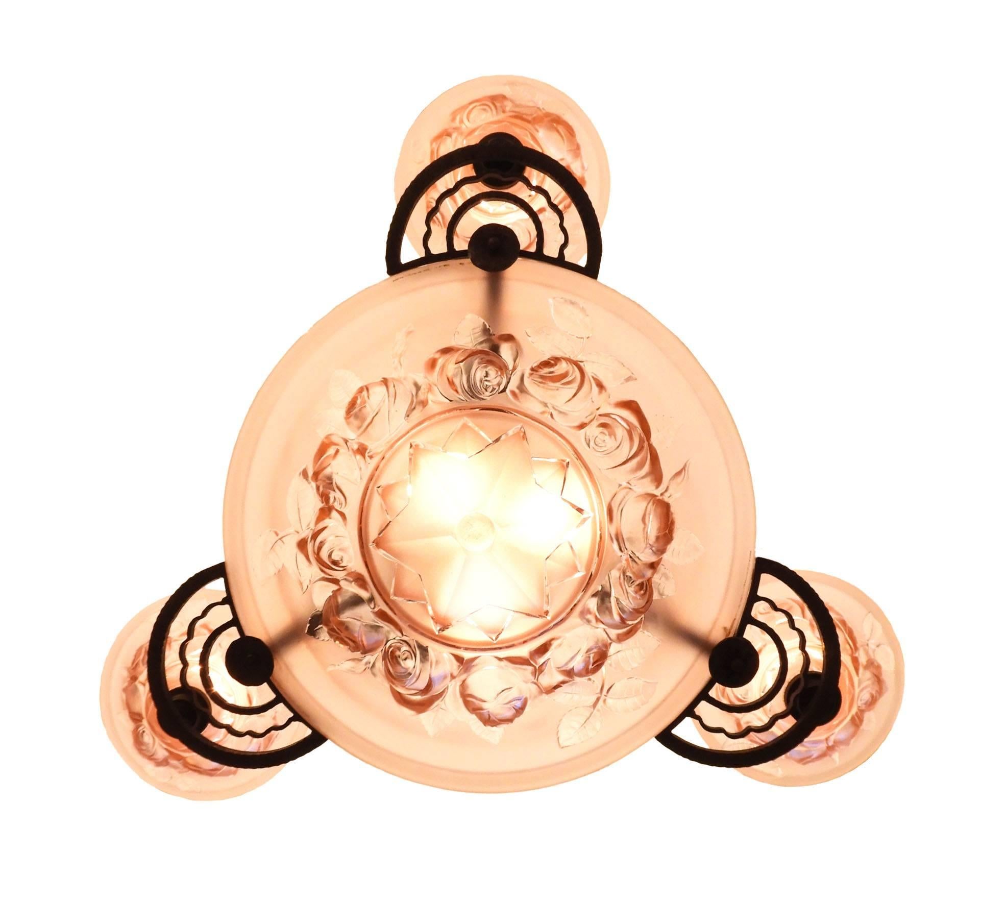 Art Deco chandelier Edgar Brandt inspired wrought iron ceiling fixture
French frosted rose glass bowls, circa 1930.
This French Art Deco chandelier features handcrafted wrought iron possibly by Edgar Brandt
with a large central glass bowl and