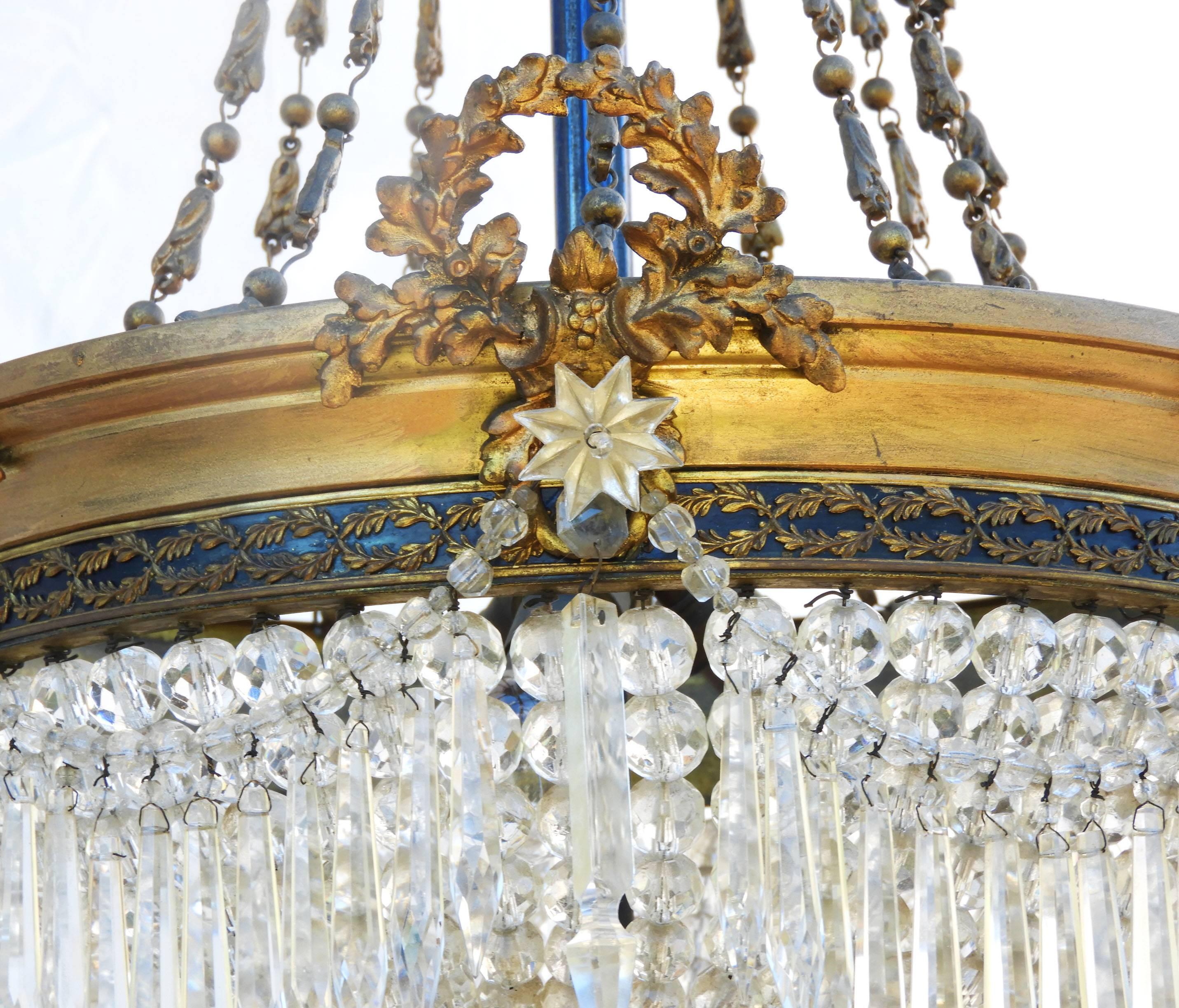 Belle Époque gilt bronze and crystal basket chandelier with three frosted rose shades, late 19th century
Illuminated dome shape basket draped with crystal beads and swags of spear shaped crystals, three arms with original frosted glass rose shades,