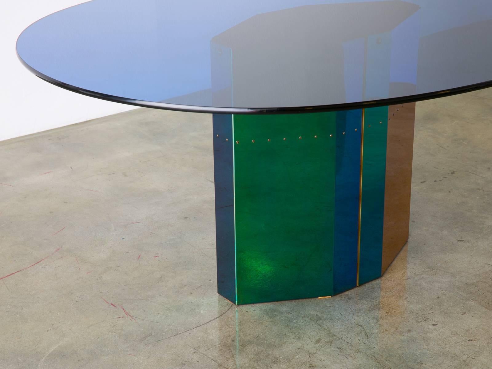 The 'Polygonon' table by Afra & Tobia Scarpa for B & B Italia, 1984. This oval table was part of a series of four base designs by the Scarpas that explored press-formed stainless steel electro coated with an iridescent finish. The glass top with