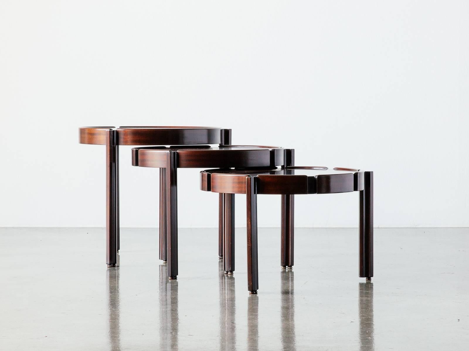 Ingenious and efficient set of three Italian stacking side tables beautifully veneered in rosewood and mahogany from the late 1960s. Each table sits on three legs with edge grooves that allow for the taller table to slot in above. Recently