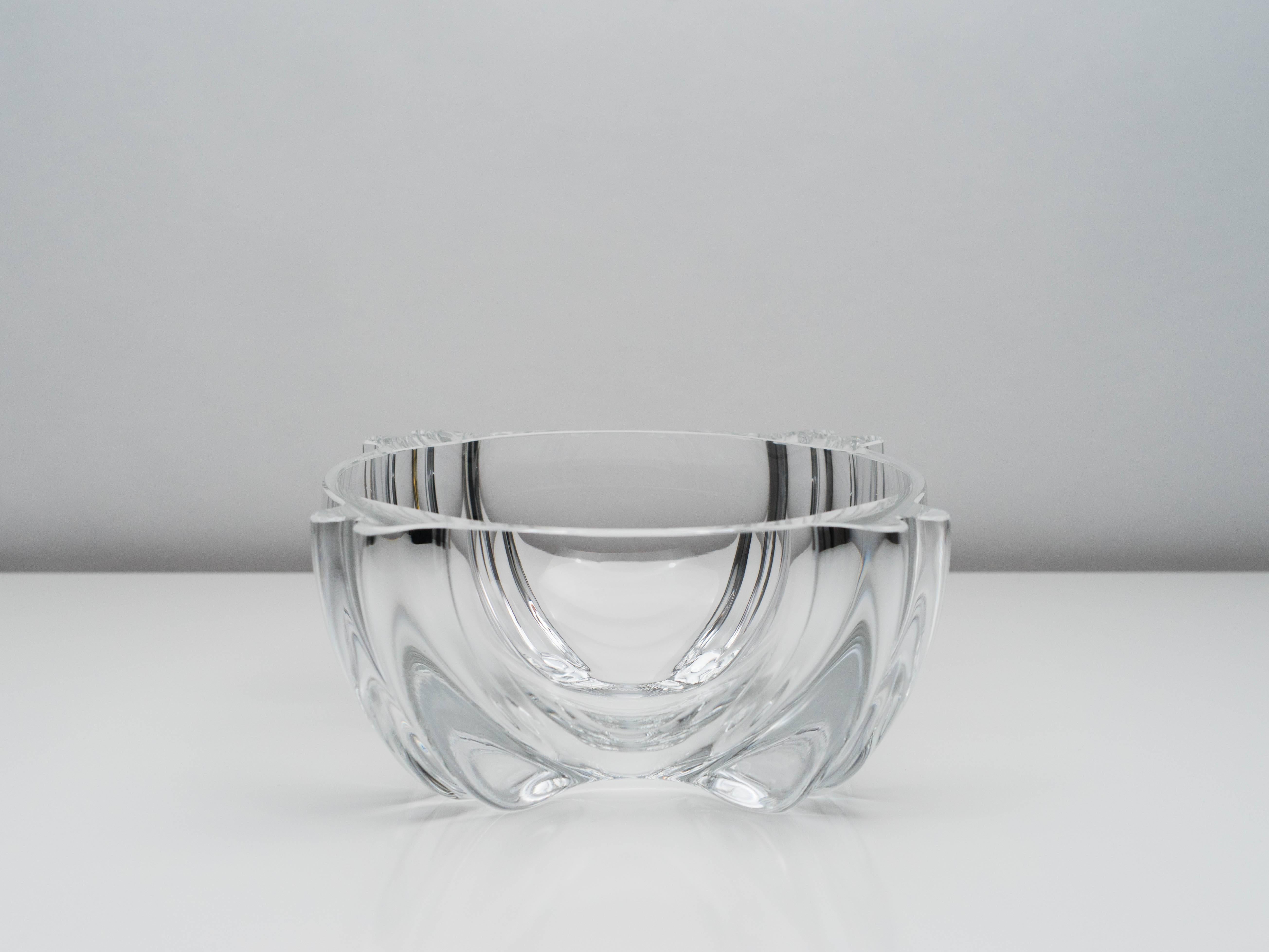 Large clear blown glass bowl or centerpiece by Barbini Murano for Oggetti. Four thick double-ridged extrusions flow down its sides, creating eight feet at its base that suspend the center bowl. The interior and exterior of the top edge is finely