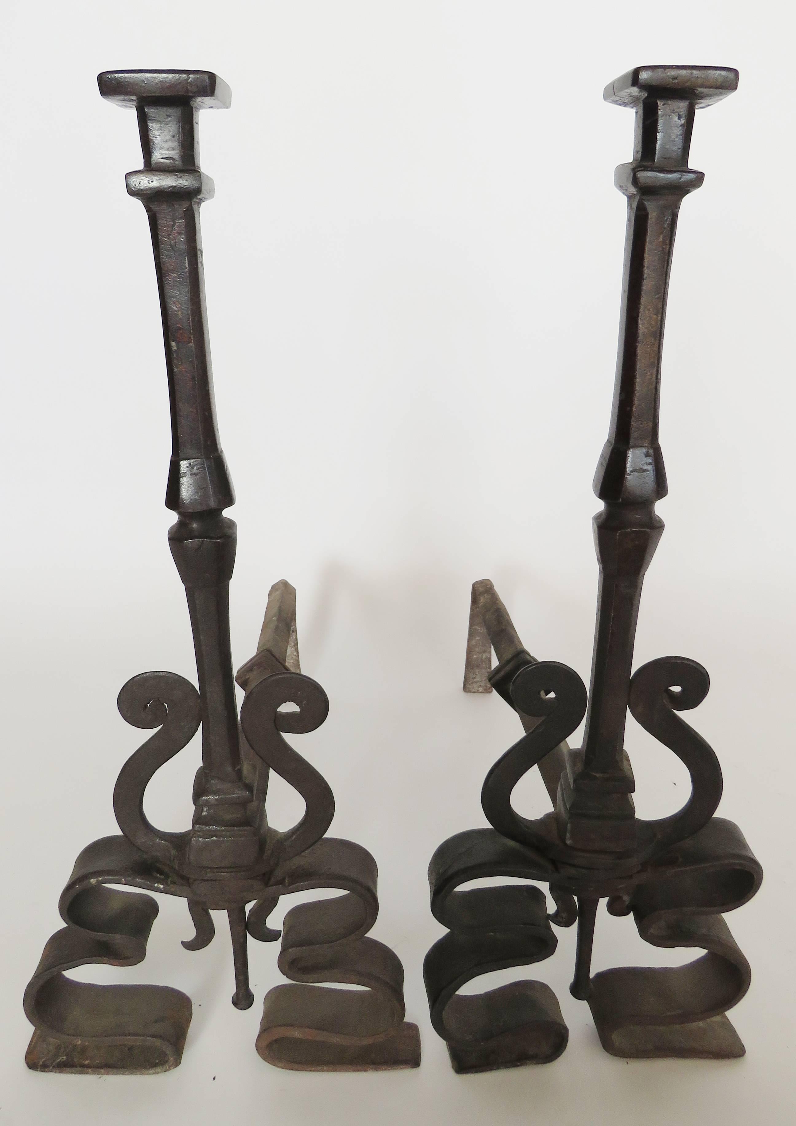 Etched wrought iron andirons with knob finials over scroll bases.