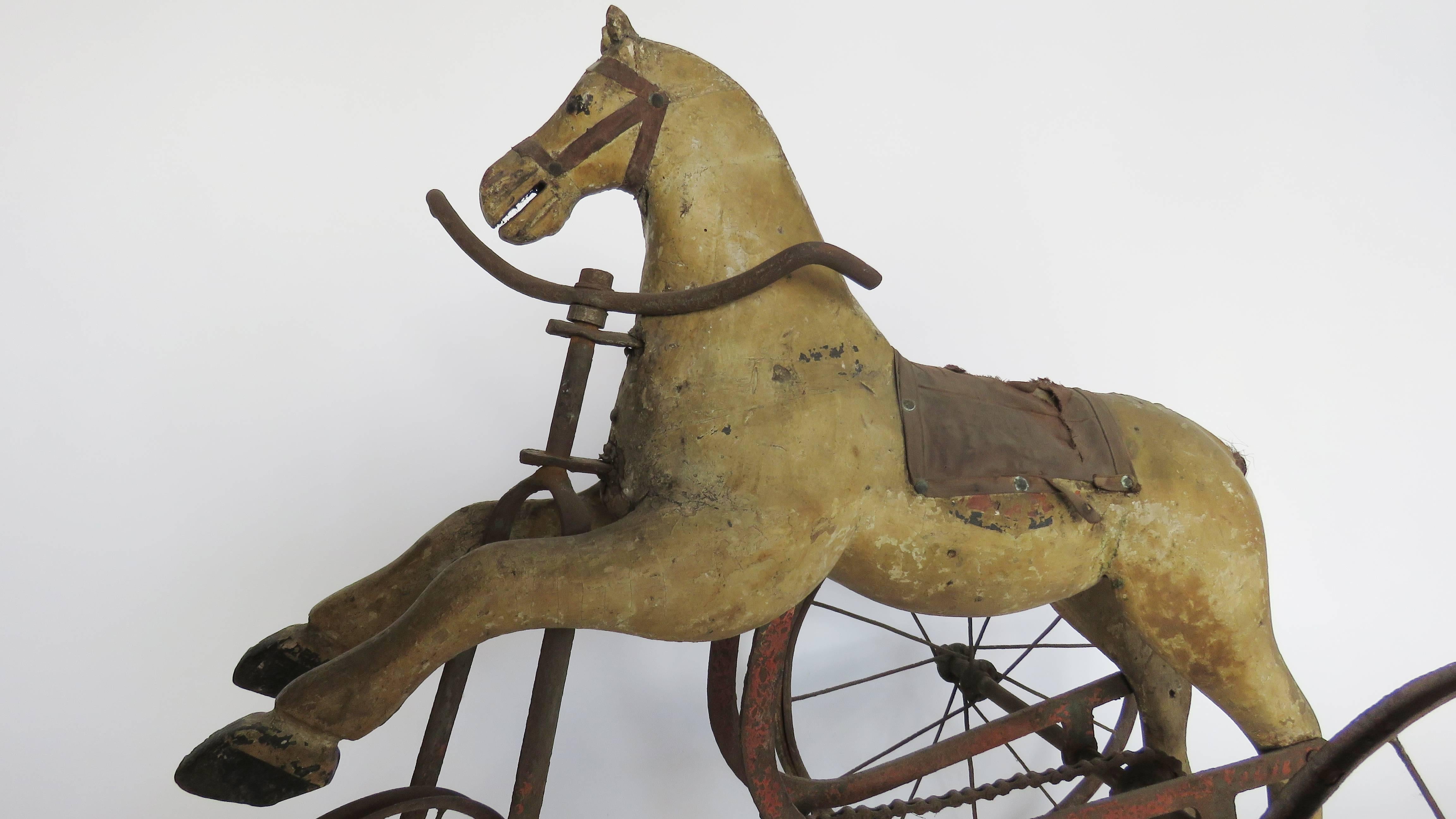 Wooden painted horse mounted on tricycle base.