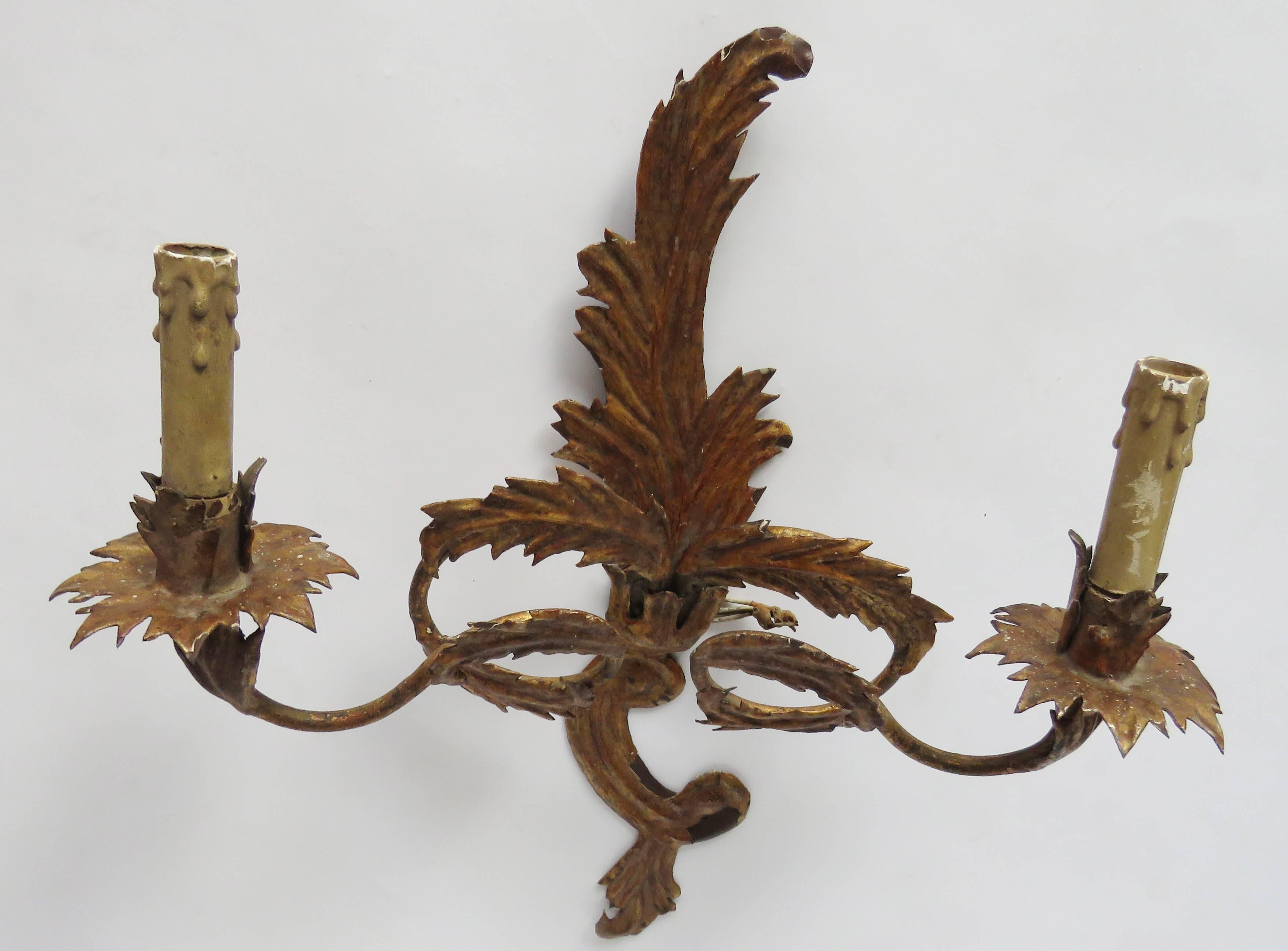 Pair of gilt tole foliate motifs sconces with two electrified arms. Great patina.