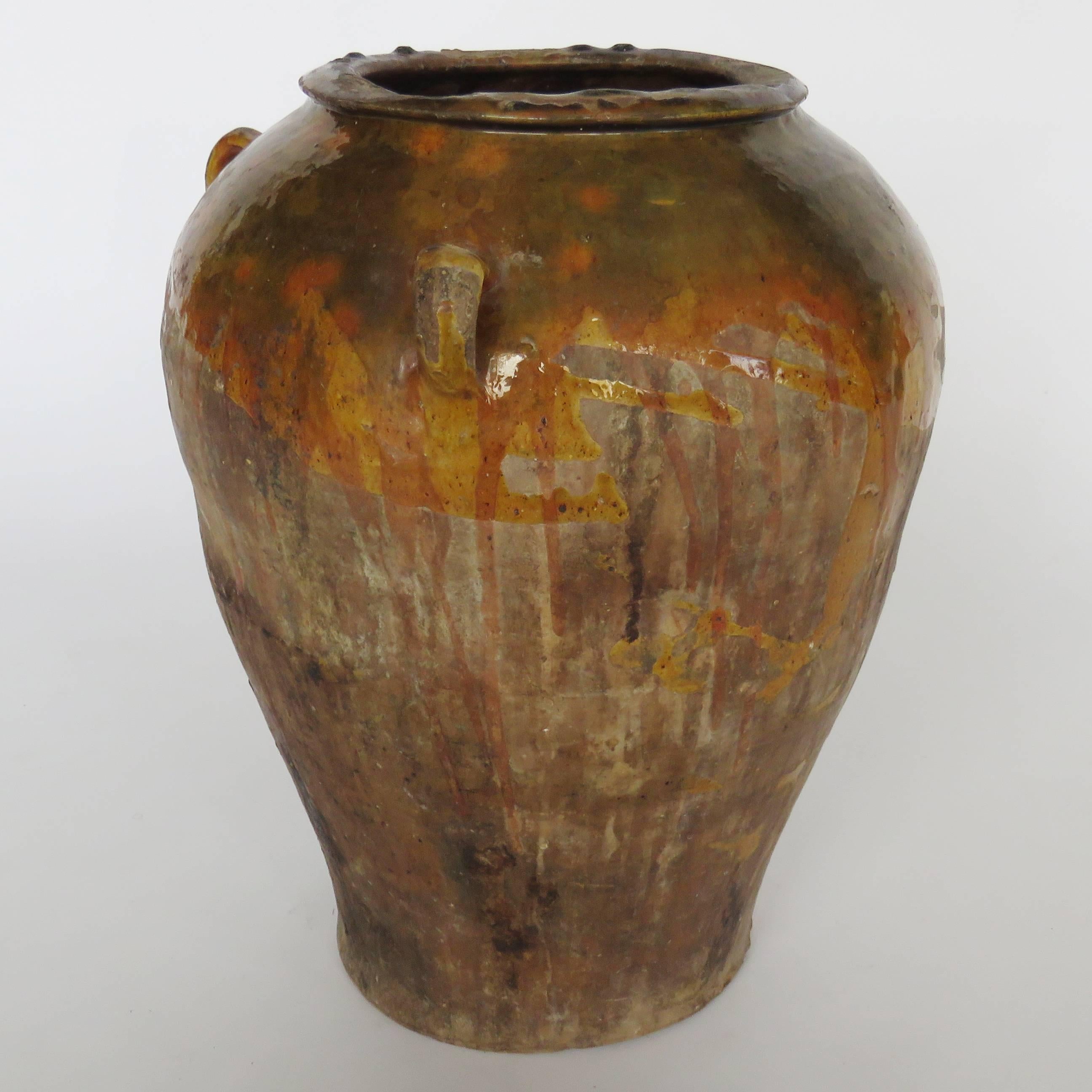Hand coiled pot with handles decorated with forest green and rust brown drippy glaze around neck.

Shipping costs per item diminish with purchases of additional items. 
Photo of collection of pots it is to show more are available. Other pots are