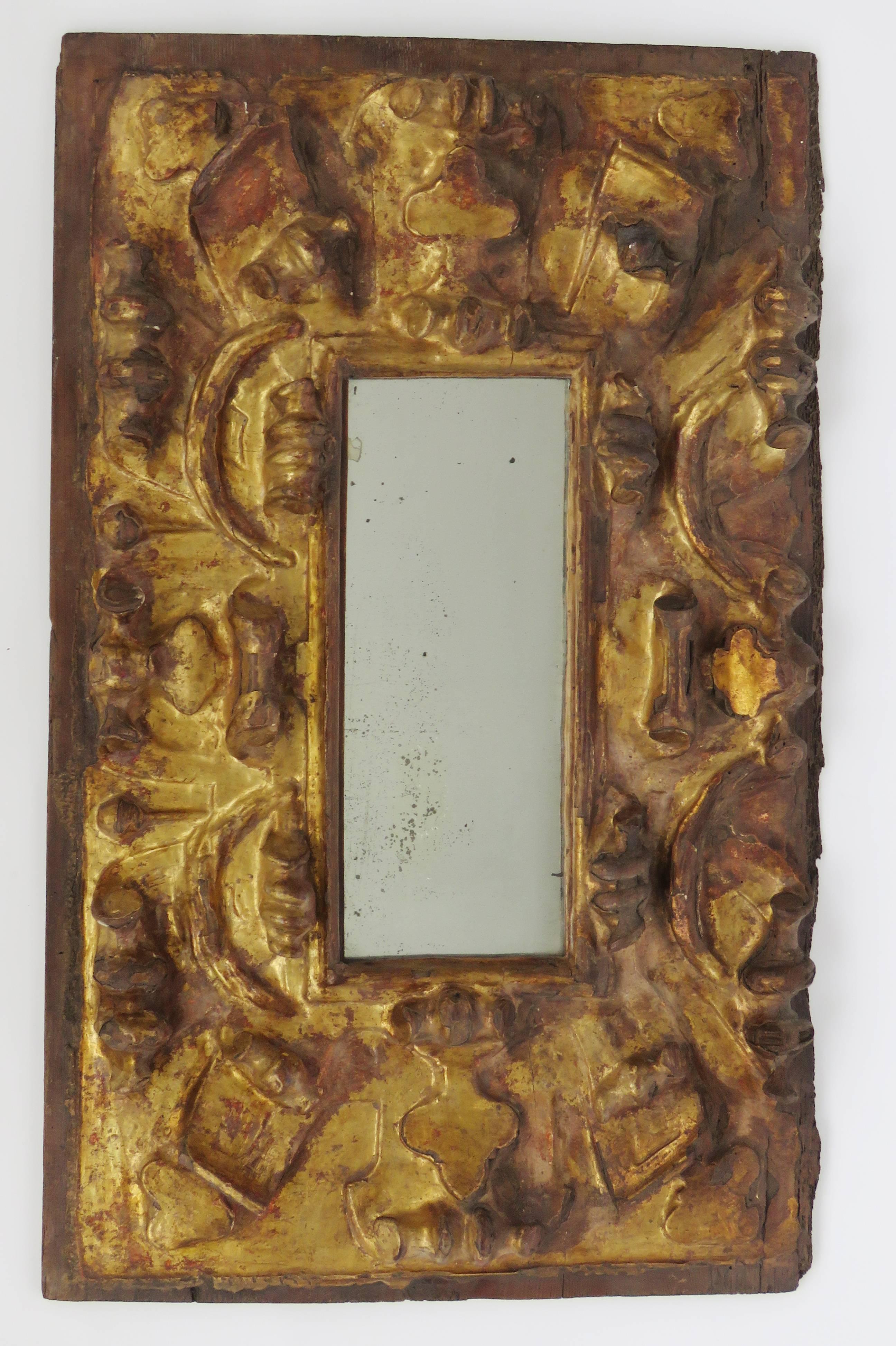 Distressed slim rectangular mirror plate surrounded by an exuberant gilt foliage.