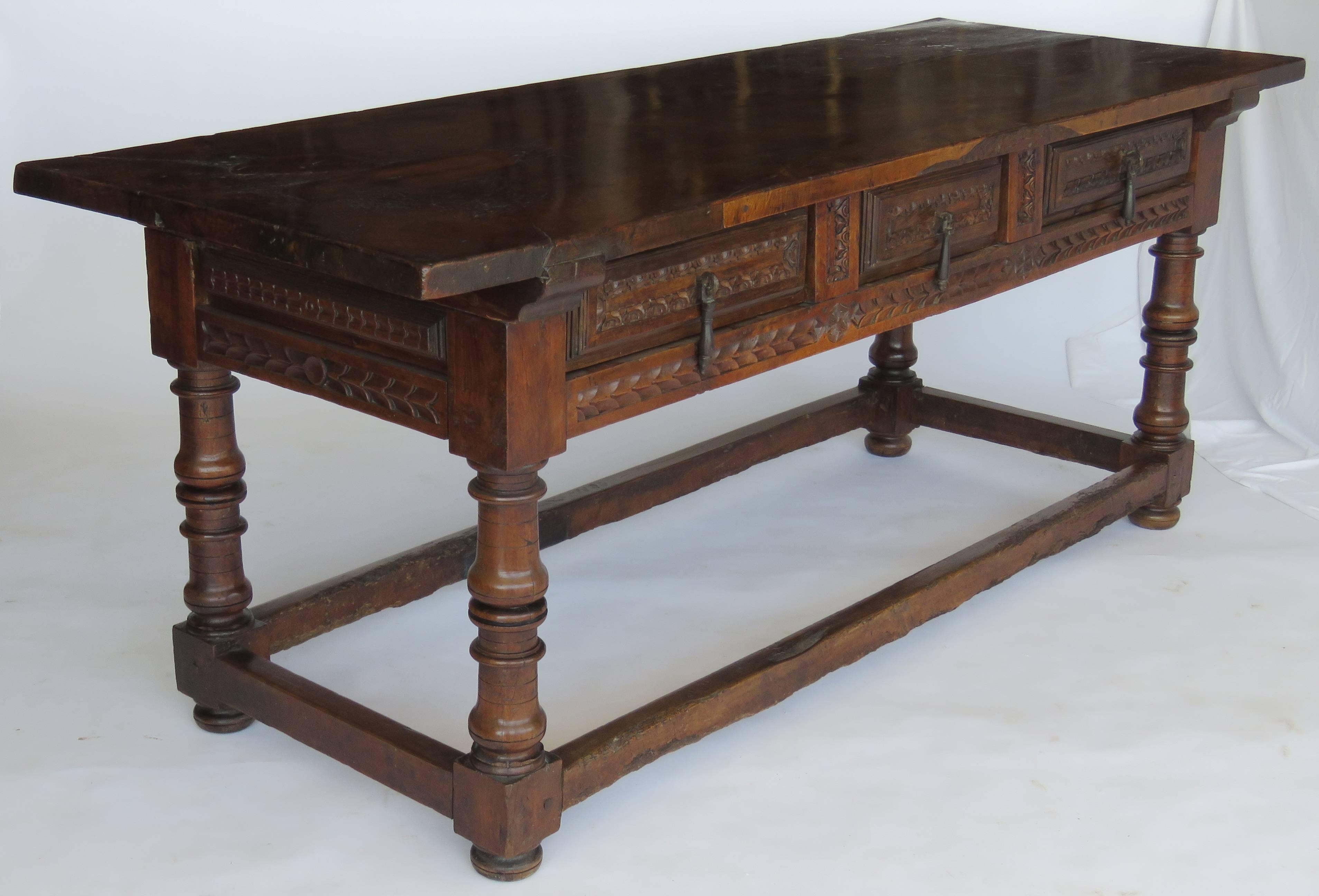 Rectangular solid single plank top above a frieze fitted with three carved drawers, sides and back similarly carved raised on vasiform turned legs joined by perimeter stretcher on compressed bun feet

Exceptional patina.