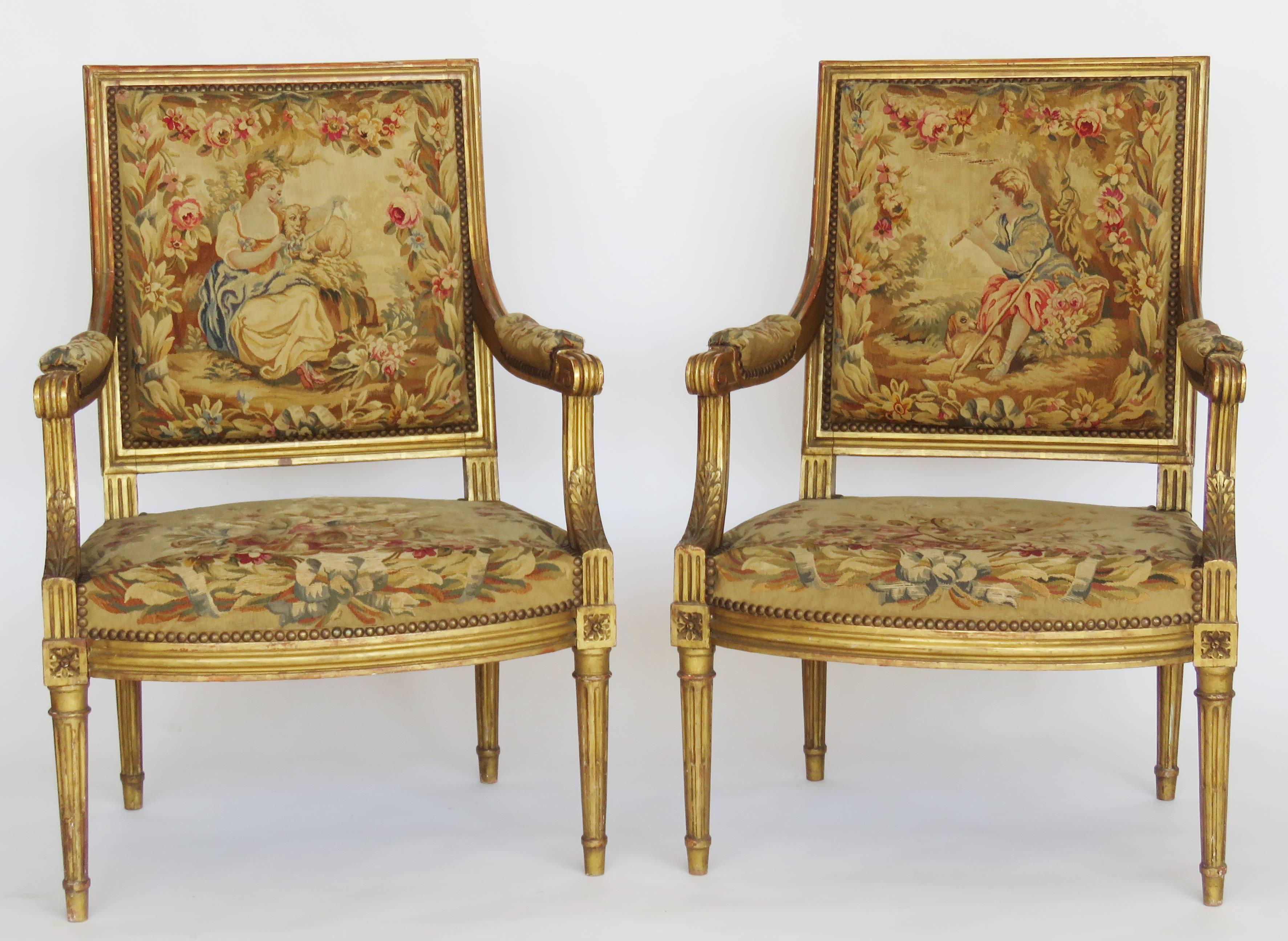 Giltwood Louis XVI style three piece parlour set comprises canapé and pair armchairs, rectangular backrest over downcurving arms and shaped seat raised on fluted tapering legs, upholstered in fine Aubusson tapestry, the backs depicting floral