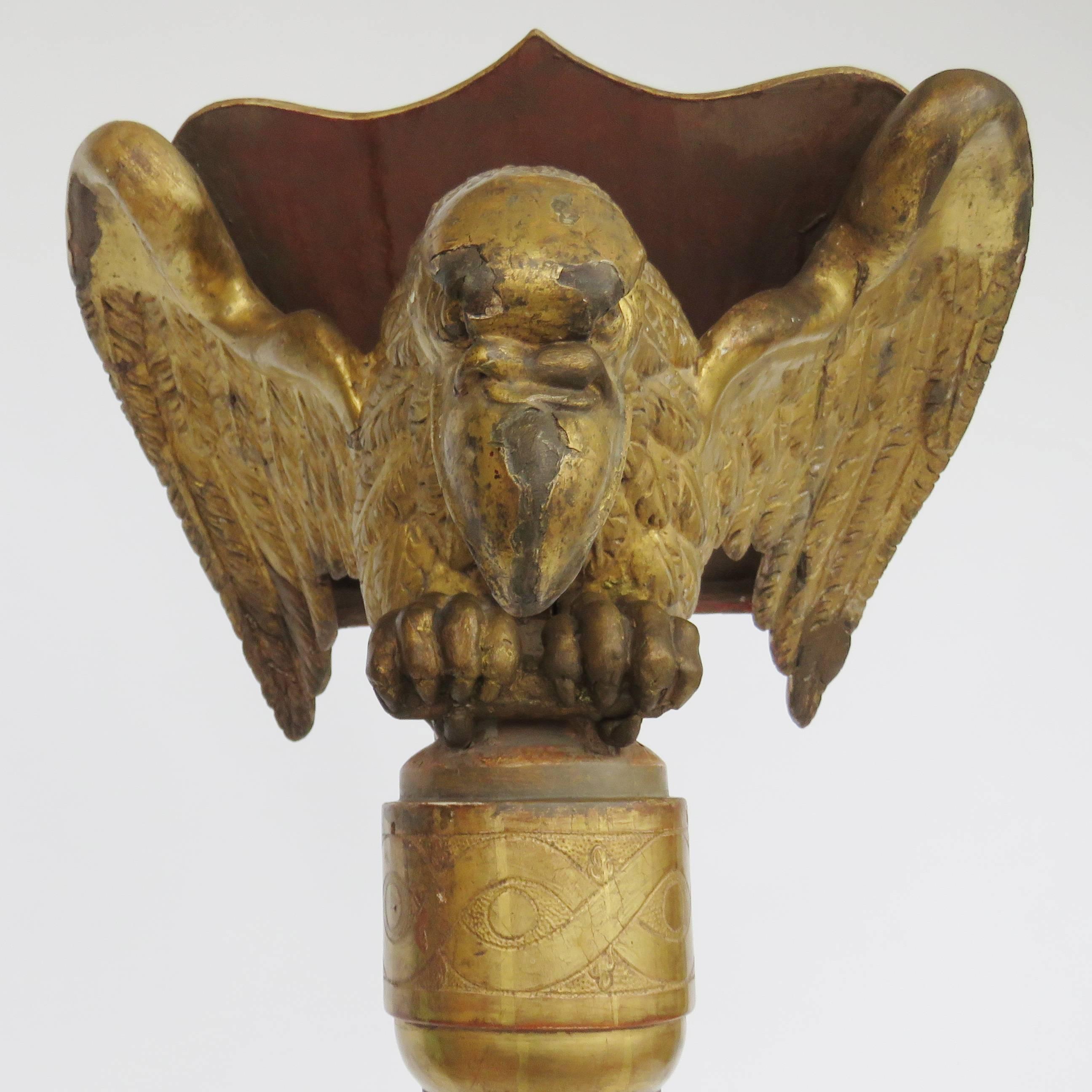 Hand-carved lectern with the natural form of the gilt eagle over a tripod gilt and red painted stand. A bookrest hinges on the eagles back.

 