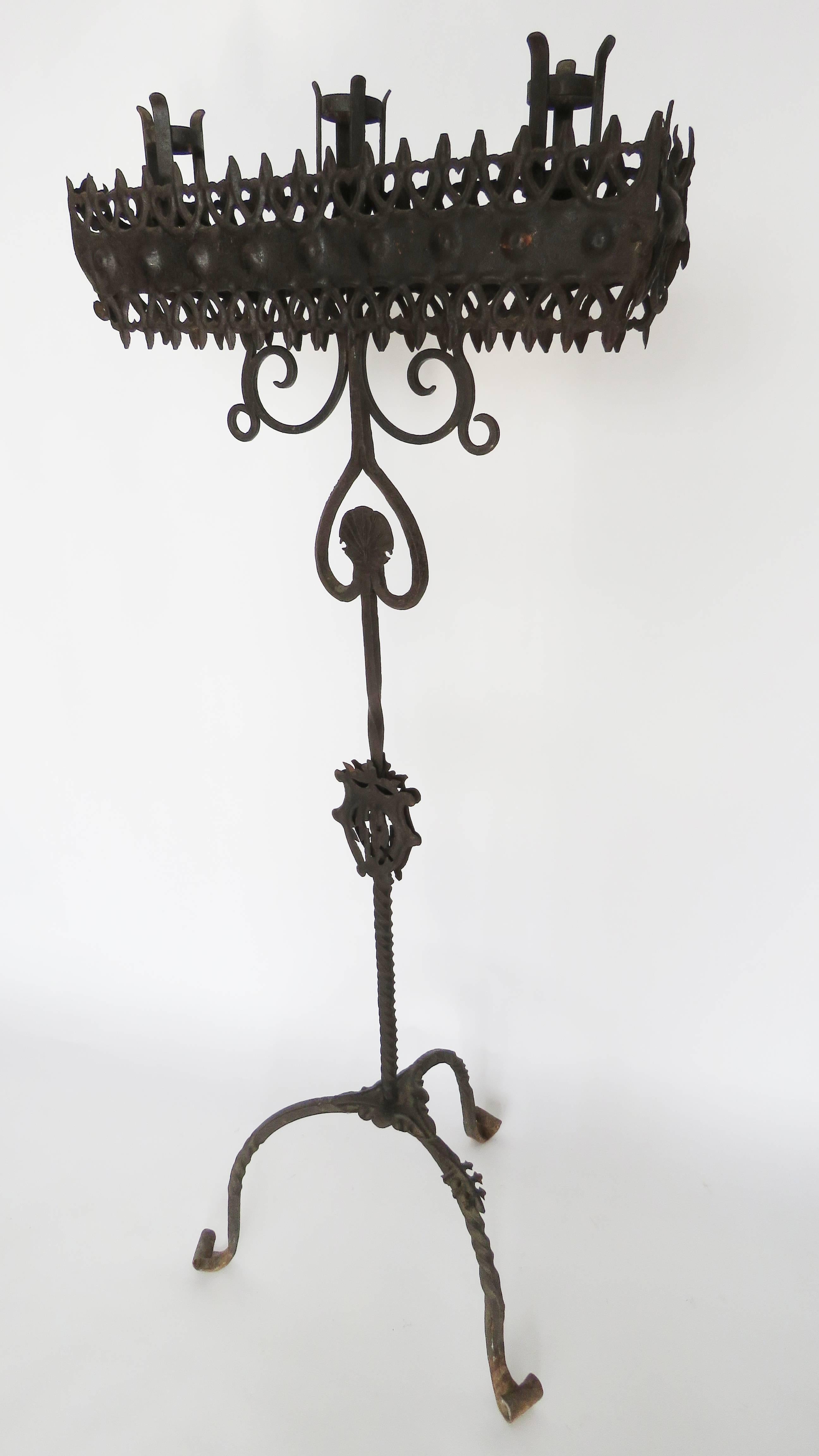 Three candle light surrounded by elaborately decorated platform on a twisted rod standard supported by tripod base. It could be reconverted into floor lamp if rewired. Beautiful age patina.